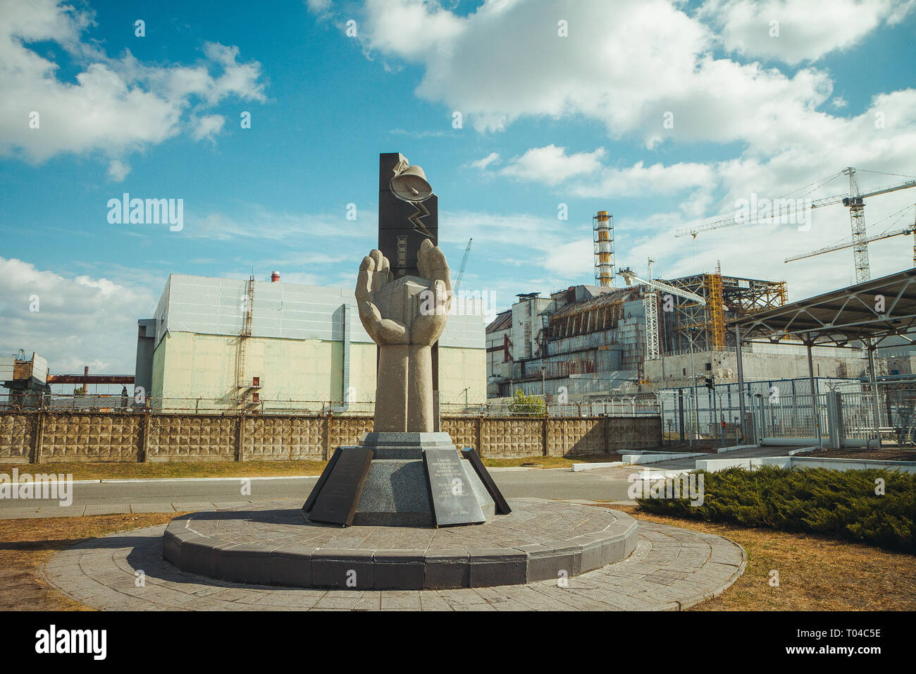 Denkmal für die Liquidatoren von Tschernobyl und der vierte Reaktor ohne umschließende Sarkophag. Tschernobyl - ChNPP. Radioaktive Zone in Stockfoto