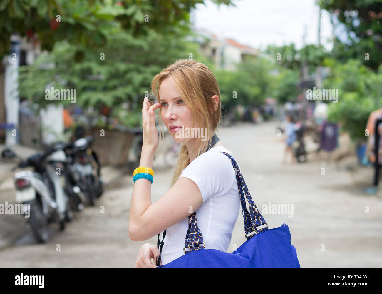 Junge attraktive Frau mit blauen Handtasche auf der Straße Stockfoto