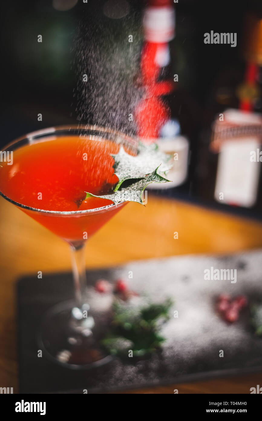 Weihnachten Cocktail mit Stechpalme und Puderzucker garnieren Jetzt' Stockfoto