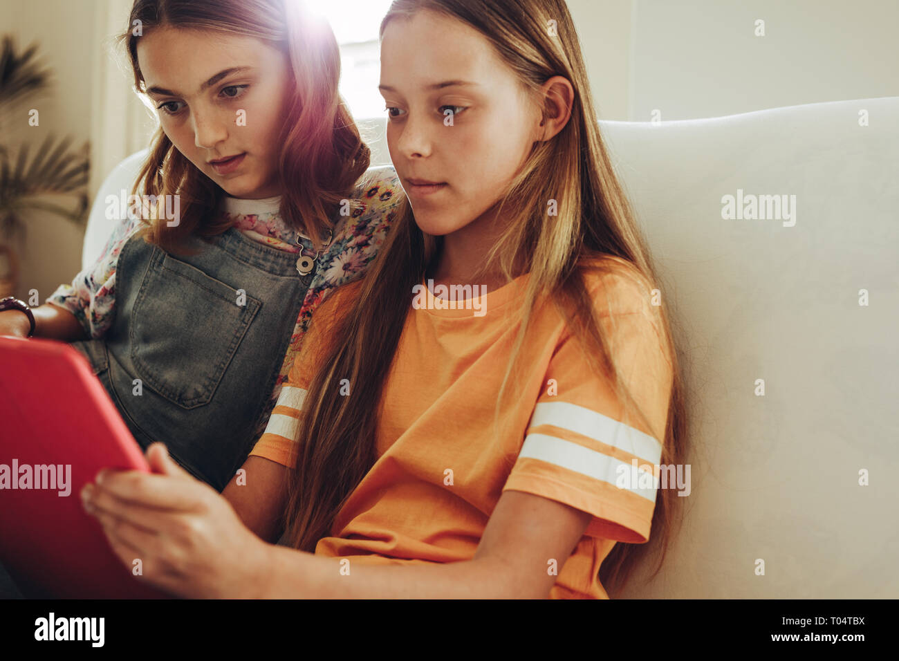 Zwei Mädchen einen Film auf einem Tablet PC, zu Hause zu sitzen. Junge Mädchen zusammen zu Hause sitzen mit tablet pc, neue Dinge zu lernen. Stockfoto