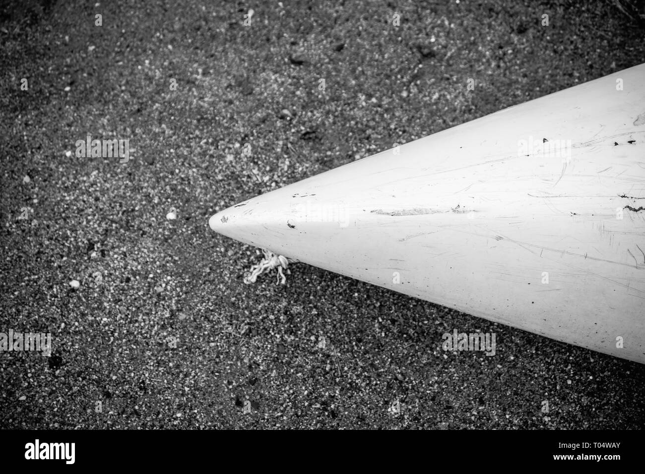 Kajak aus weißem Fiberglas Kunststoff mit im Alter von Markierungen auf dem Strand mit schwarzem Sand und Steine am Meer mit keine Menschen, Hintergrund mit Copyspace Stockfoto