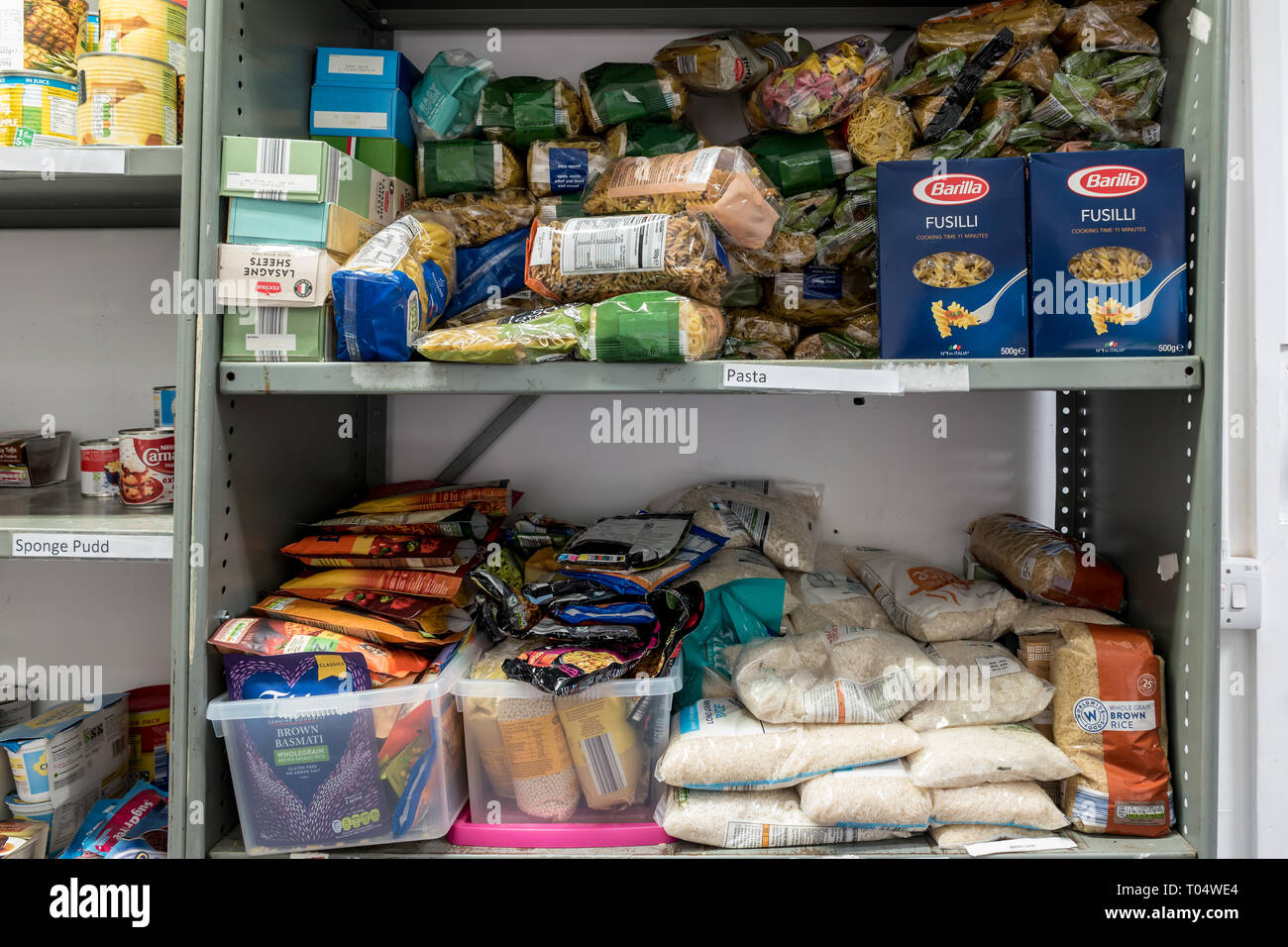 Ablagen in einem britischen Trussell Vertrauen lokalen Kirche food bank Lager Übersicht Pakete von trockenen Gütern, Reis und Nudeln, bereit für Lebensmittelpakete Stockfoto