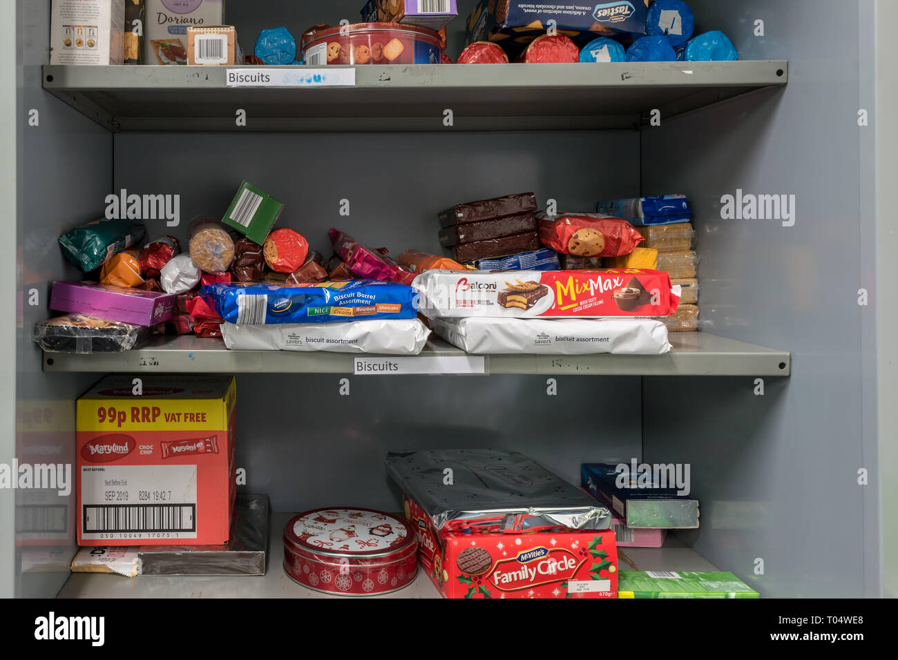 Ablagen in einem britischen Trussell Vertrauen lokalen Kirche food bank Lager Kekse angezeigt und Leckereien bereit für Lebensmittelpakete Stockfoto