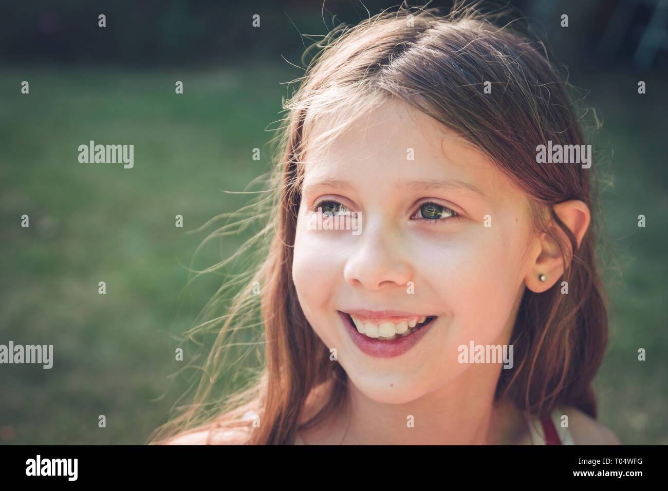 Entspannt im Freien Portrait von weißen Mädchen lächelnd und glücklich, den Blick zur Seite Stockfoto