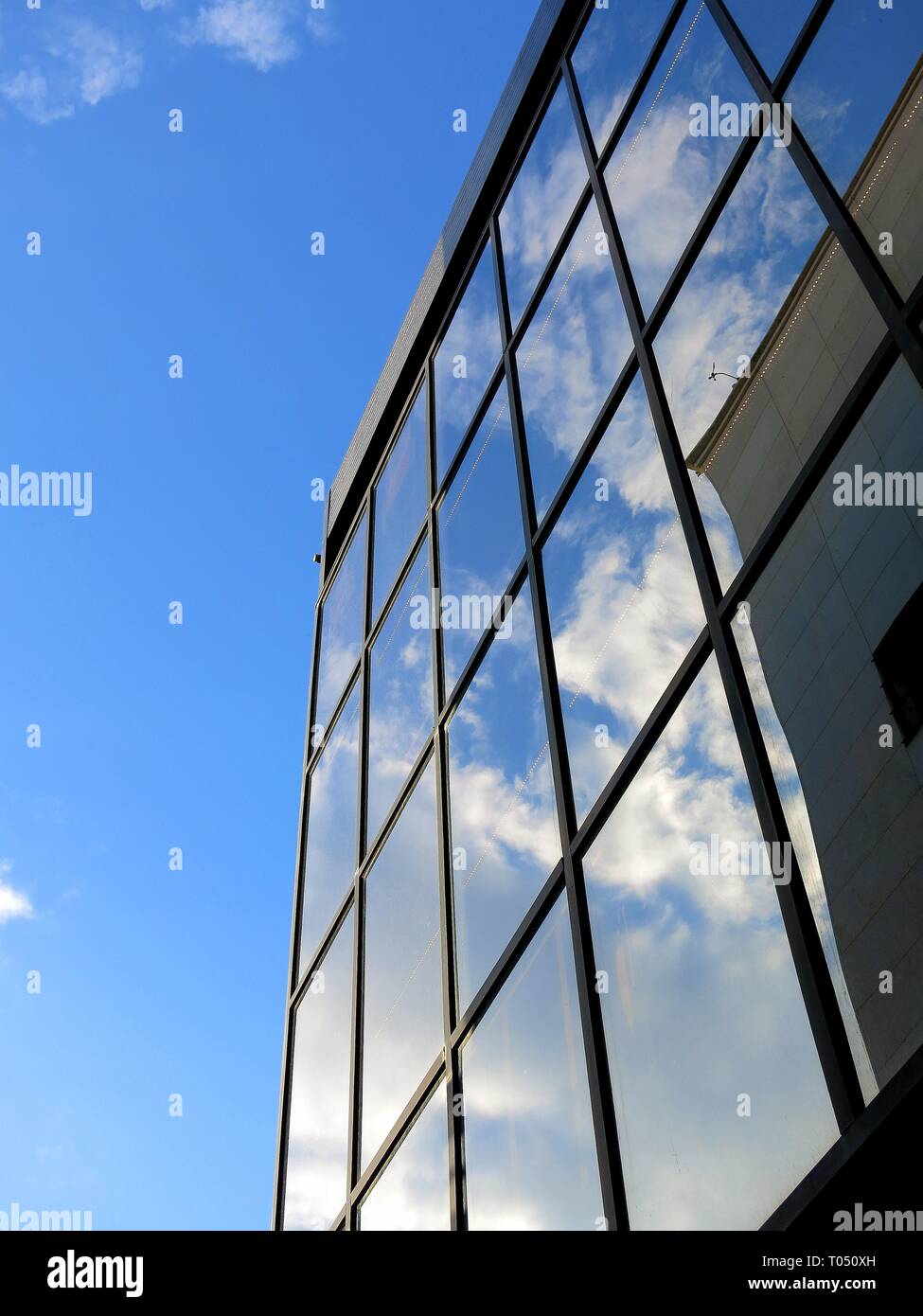 Reflexion von Wolken an den Fensterscheiben eines Gebäudes. Stockfoto