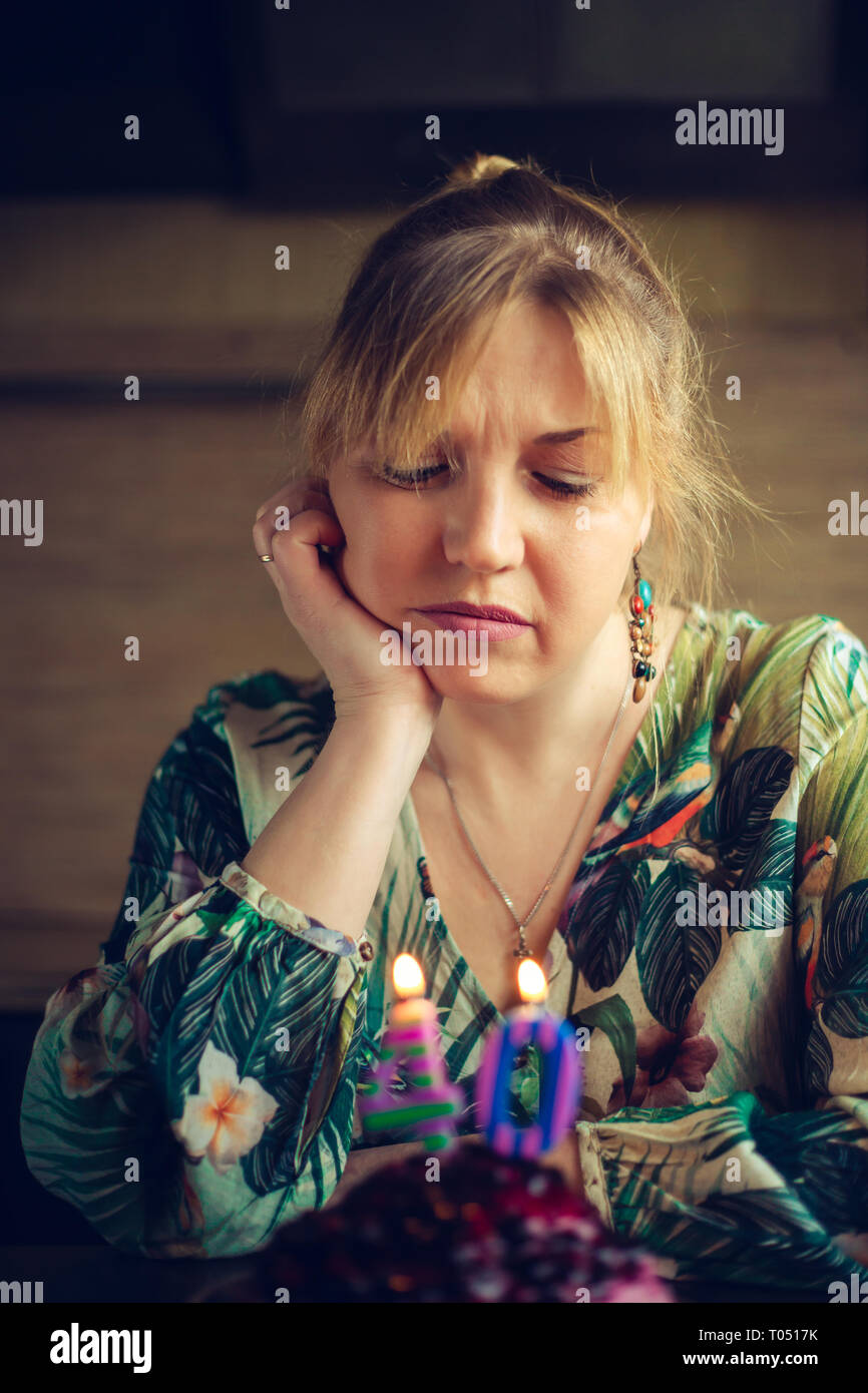 Schön traurig Kaukasischen blonde Frau feiert Geburtstag mit Geburtstag Kuchen. Selektive konzentrieren. Stockfoto