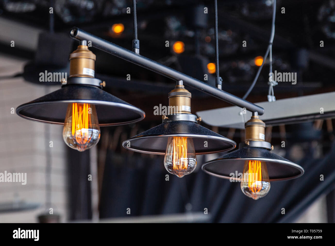 Schwarzes Eisen loft Kronleuchter mit Edison Lampen auf schwarzem  Hintergrund, Bokeh. Konzept des modernen Inneneinrichtung der ein  Restaurant, ein Café, eine Wohnung, Büro Stockfotografie - Alamy