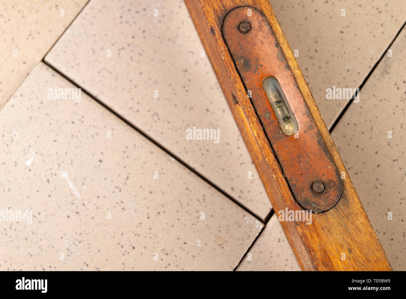 Die Messung der Neigung der Oberfläche mit einer Wasserwaage. Mess Zubehör für Mechanik. Der dunkle Hintergrund. Stockfoto