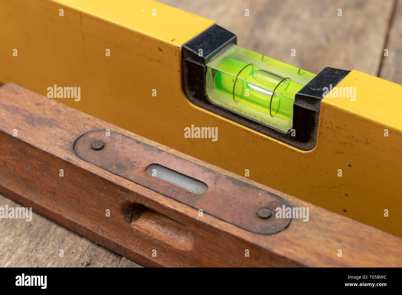Die Messung der Neigung der Oberfläche mit einer Wasserwaage. Mess Zubehör für Mechanik. Der dunkle Hintergrund. Stockfoto