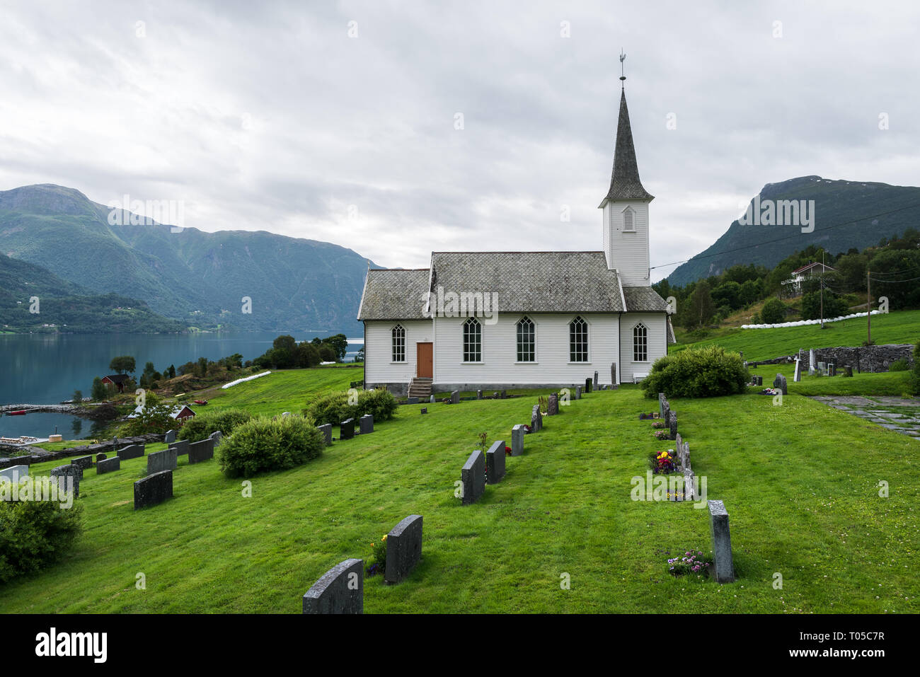 Nes kyrkje, Gemeinde Glanz, Norwegen. Weiße hölzerne Kirche und Friedhof Stockfoto