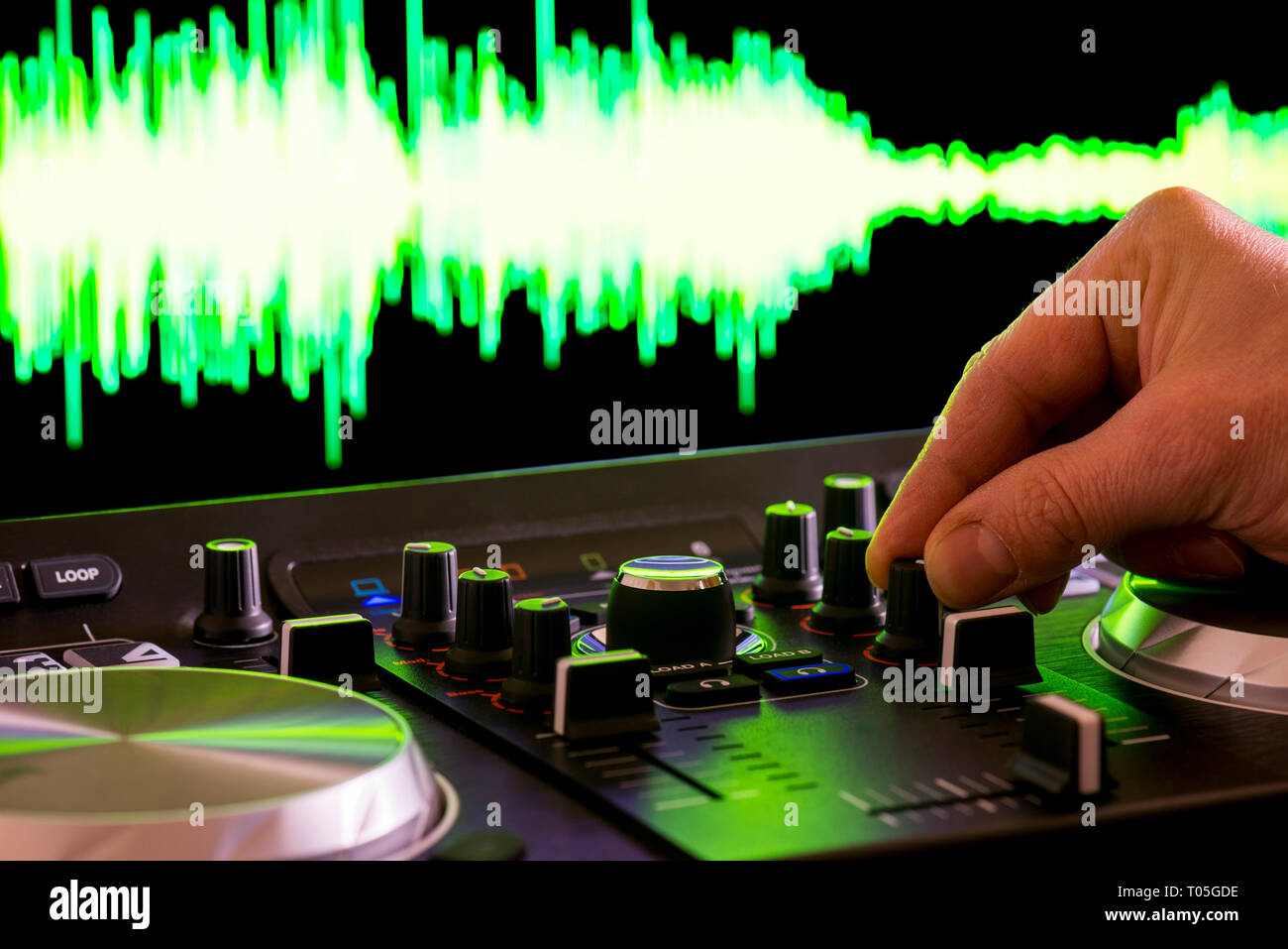 Hand auf einem dj Controler flache Tiefenschärfe, mit soundwave im Hintergrund Stockfoto