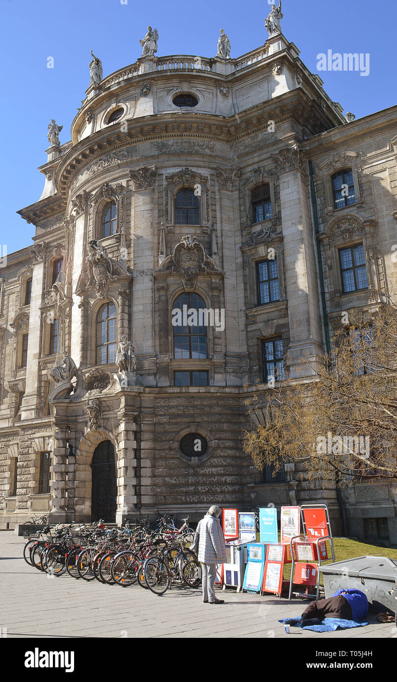 Gerechtigkeit: Ein obdachloser Mann schläft gegen ein Fach außerhalb der Palast der Justiz in München, Bayern, Deutschland Stockfoto