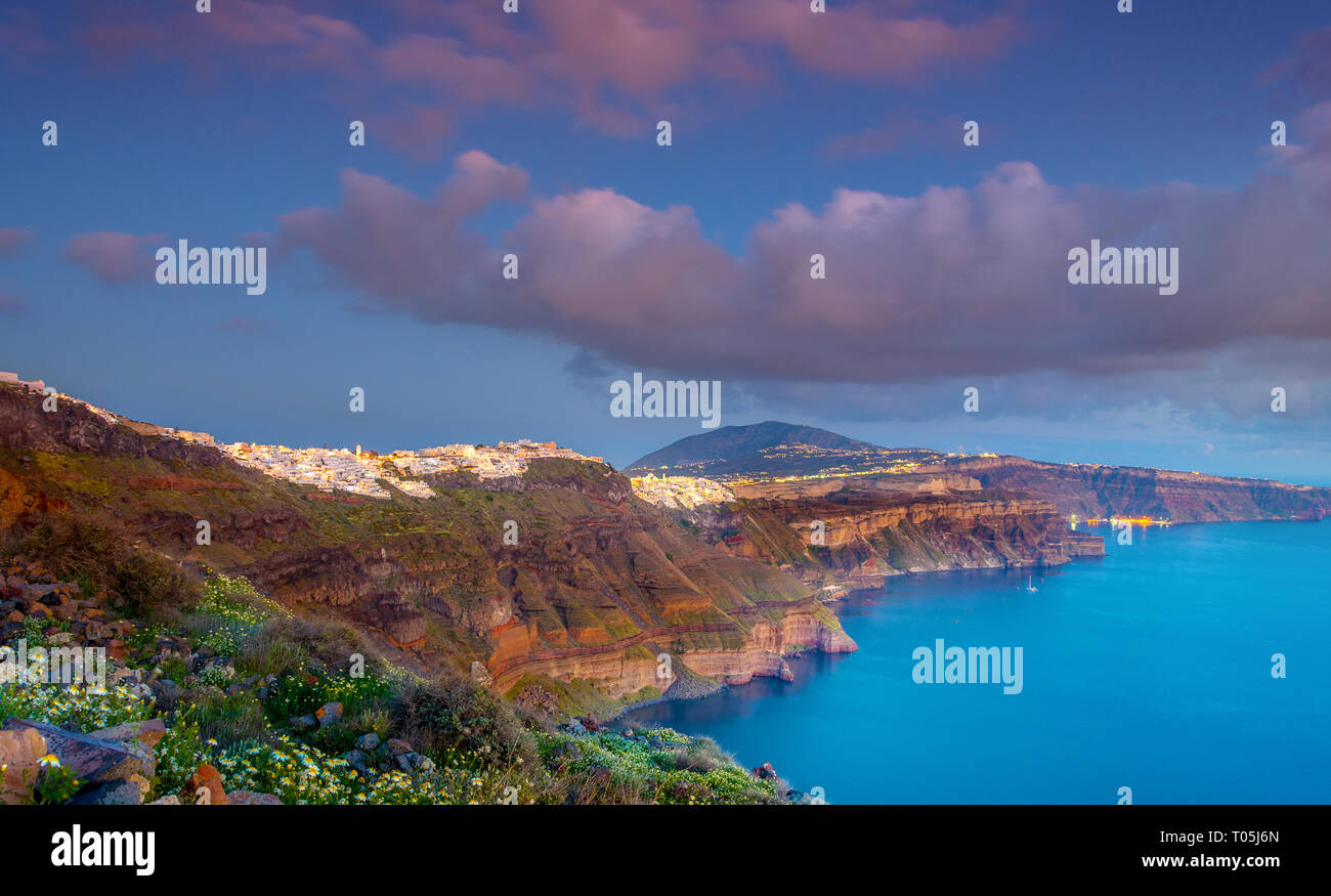 Blick am Abend von Fira, Caldera, Vulkan von Santorini, Griechenland mit Kreuzfahrtschiffen bei Sonnenuntergang. Dramatischer Wolkenhimmel. Stockfoto