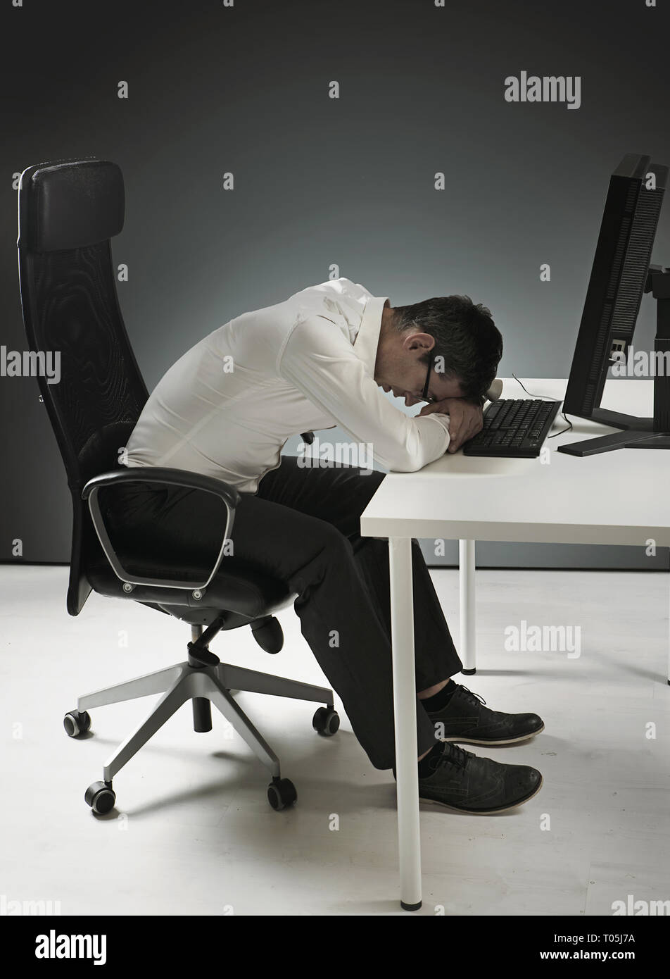 Erschöpft Geschäftsmann in ein Nickerchen auf dem Schreibtisch Stockfoto