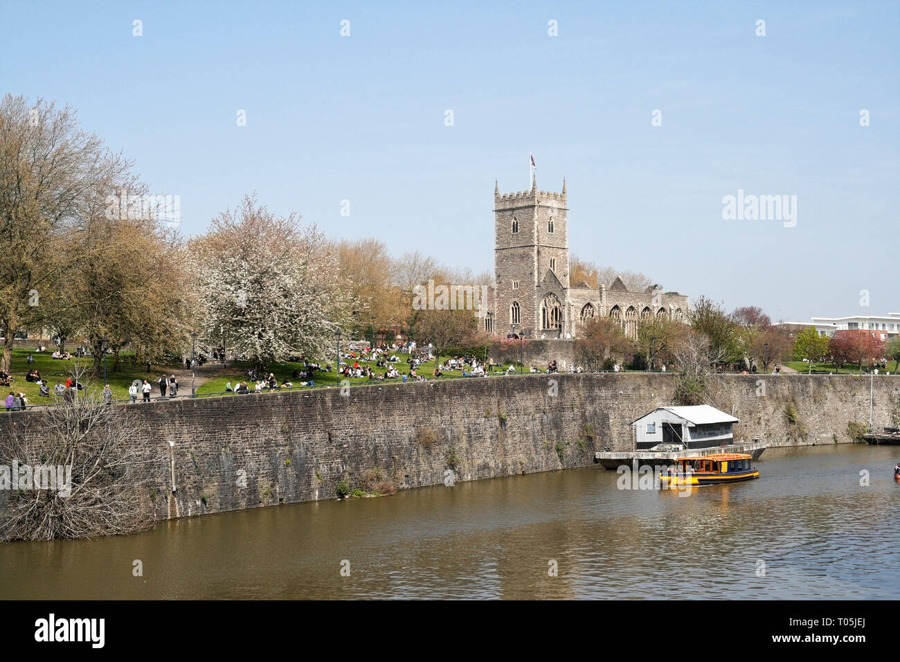 Die Reste der St. Peters Kirche im Stadtzentrum von Bristol, mit Blick auf den Fluss Avon, Menschen im Park sitzen. Stockfoto