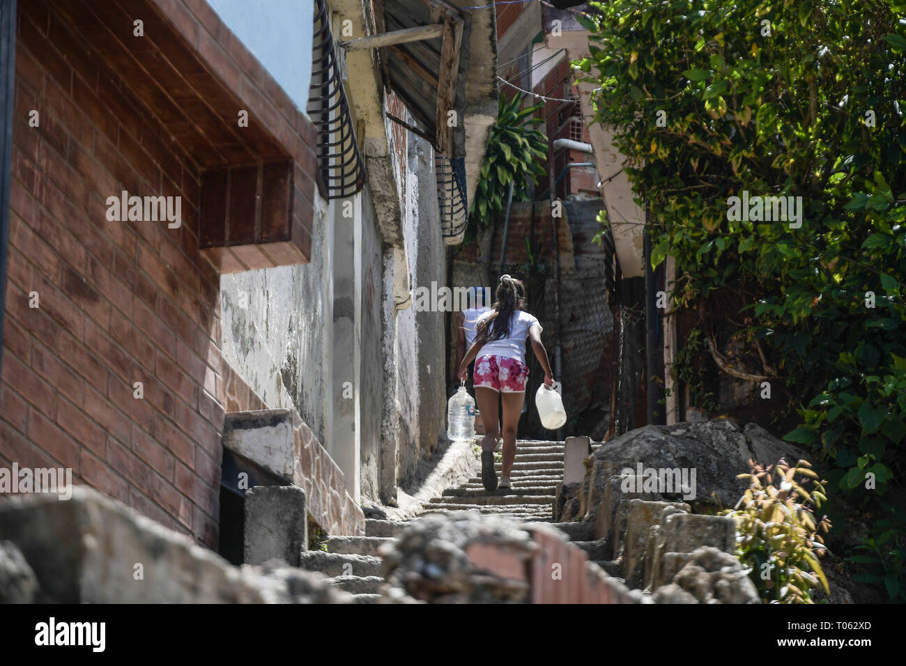 Caracas, Venezuela. 16 Mär, 2019. Ein Mädchen gesehen, die Wasser Flaschen während der Schwarzen heraus. Mangel an Wasser, den Lebensstandard in Venezuela betroffen waren, die Situation verstärkt nach einer nationalen Blackout, dass 3 Tage dauerte. Die Dienstleistungen sind stark betroffen. In Petare, einer der größten schlechte Sektoren in Lateinamerika, haben sie für mehr als 30 Tage ohne Wasser gegangen. Credit: Roman Camacho/SOPA Images/ZUMA Draht/Alamy leben Nachrichten Stockfoto