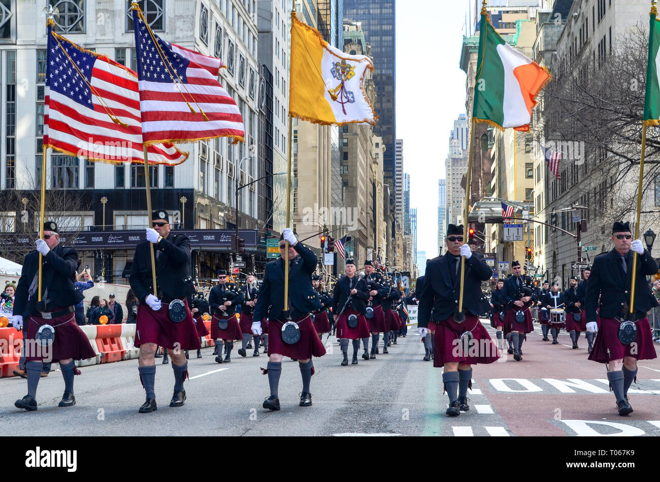 New York City, USA. 16 Mär, 2019. Menschen gehen mit irische und amerikanische Flaggen während des St. Patrick's Day Parade entlang der 5th Avenue. Credit: jbdodane/Alamy leben Nachrichten Stockfoto