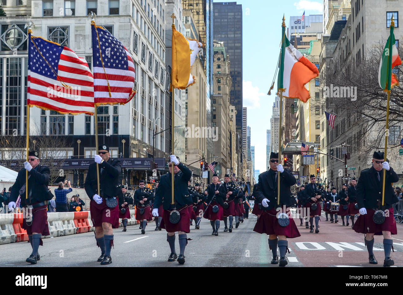 New York City, USA. 16 Mär, 2019. Menschen gehen mit irische und amerikanische Flaggen während des St. Patrick's Day Parade entlang der 5th Avenue. Credit: jbdodane/Alamy leben Nachrichten Stockfoto