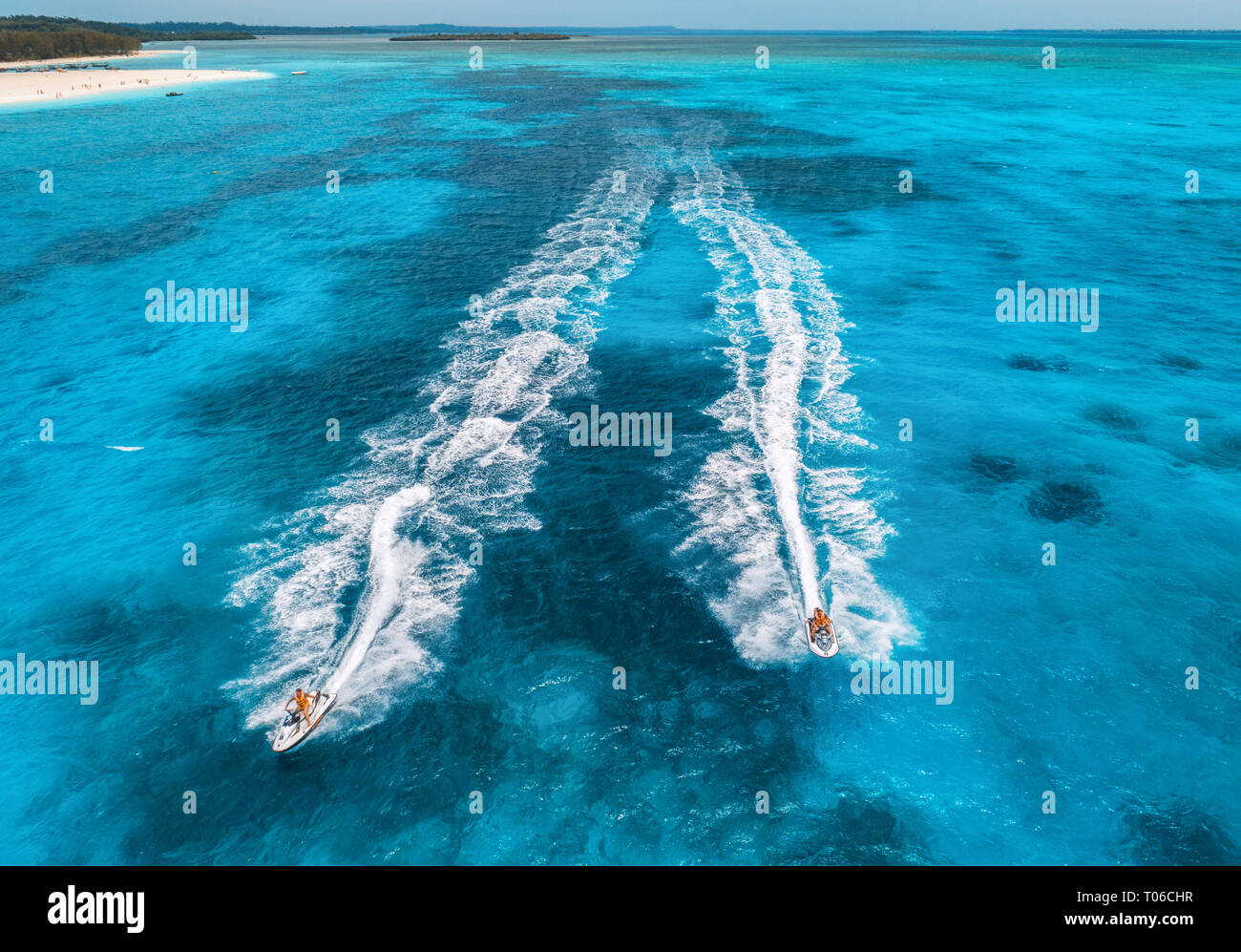 Luftbild des fließenden Wasser Scooter im blauen Wasser an einem sonnigen Tag im Sommer. Urlaub im Indischen Ozean, Sansibar, Afrika. Blick von oben auf die Jet ski in Bewegung. Stockfoto