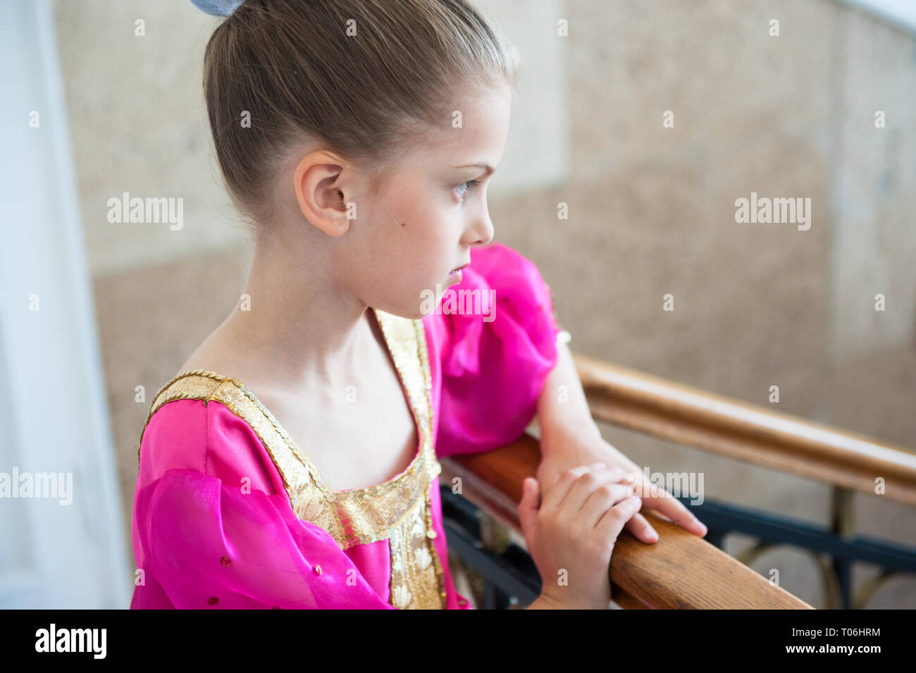 Schöne nachdenkliche kleine Mädchen in traditionellen lila Kleid steht drinnen schiefen Zusatzscheinwerfer auf dem Dach Stockfoto