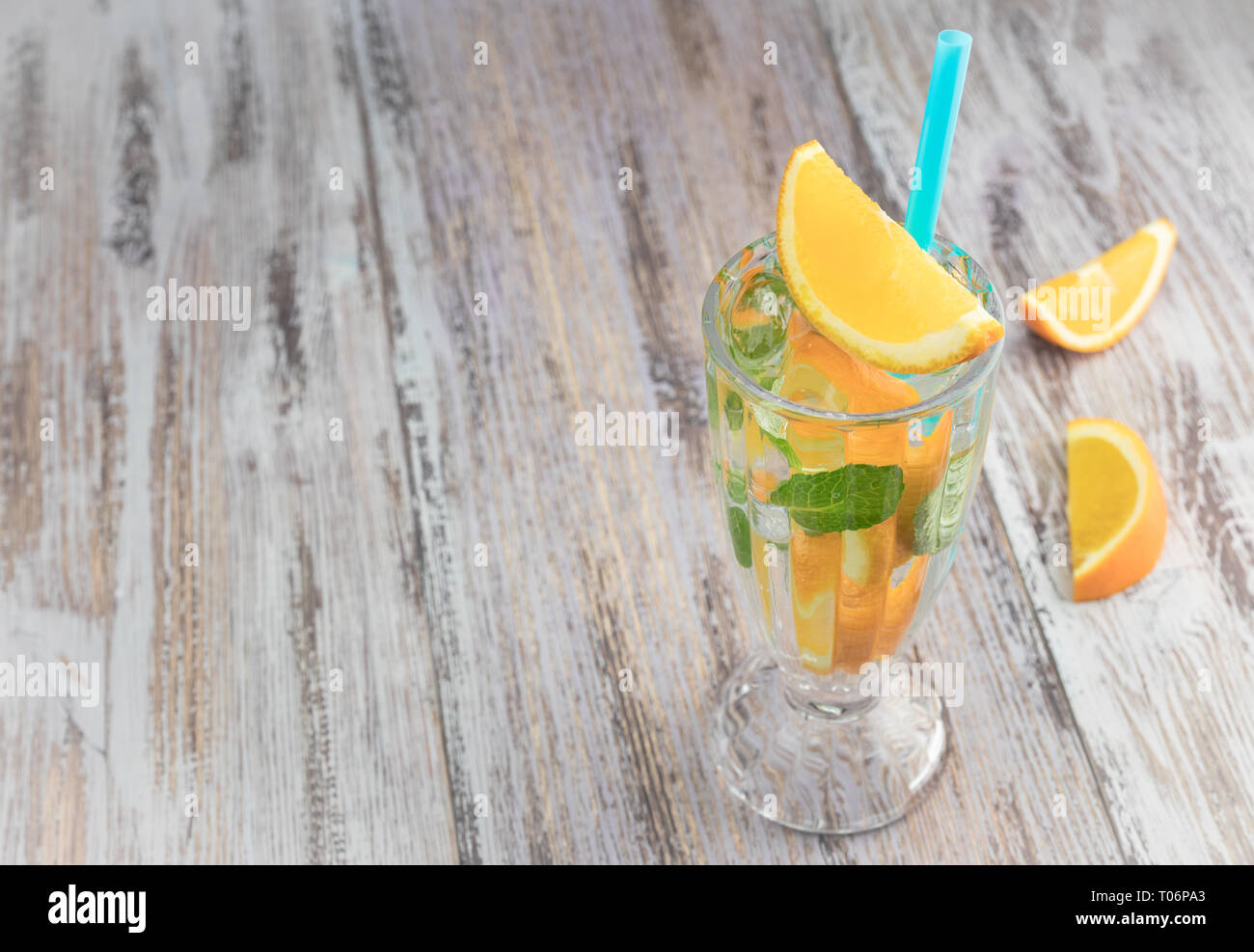 Citrus erfrischenden Drink in ein Glas Becher auf einer hölzernen Tisch. Sommer erfrischenden Cocktail. Gesundes Essen, Getränke. Orange und Minze Eiswasser. Platz kopieren Stockfoto