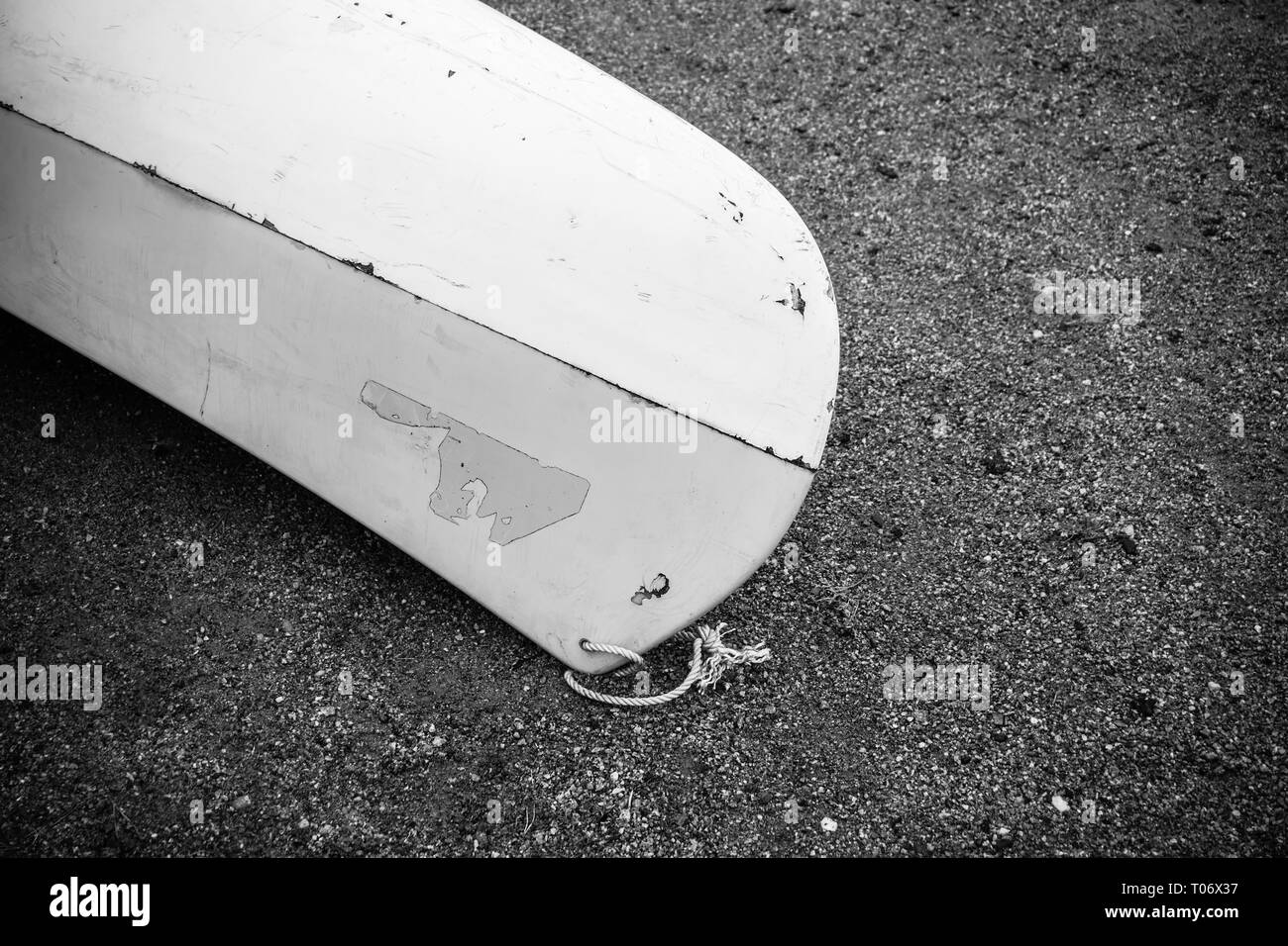 Kajak aus weißem Fiberglas Kunststoff mit im Alter von Marken mit weißen Kordel am Strand mit schwarzem Sand und Steine am Meer mit keine Menschen, Hintergrund wit Stockfoto