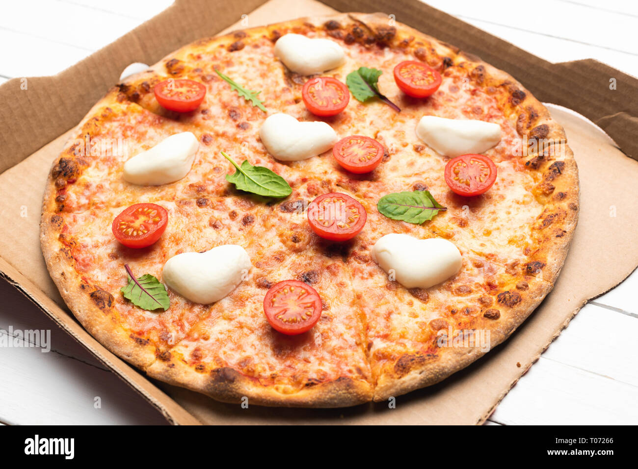 Leckere Pizza bei Pizza Box oder Karton auf weißem Hintergrund. Detailansicht Stockfoto