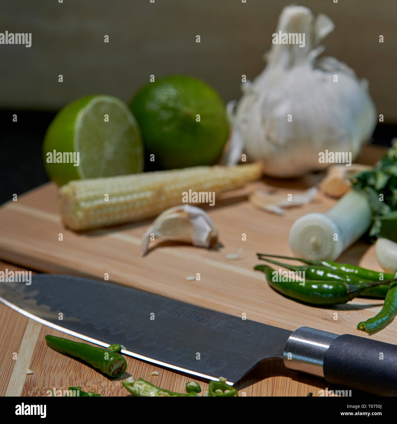 Asiatische Thai Chilis und Gemüse Zutaten auf Schneidebrett mit Santoku Messer Stockfoto