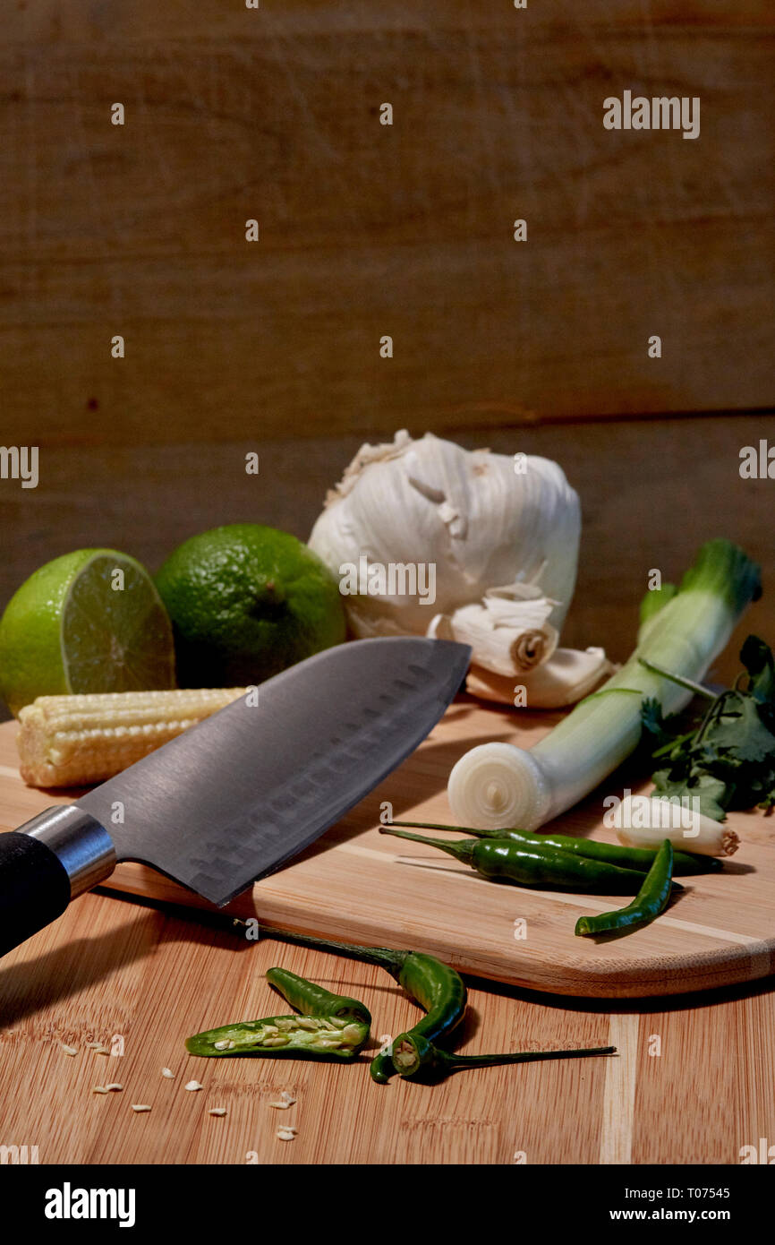 Asiatische Thai Chilis und Gemüse Zutaten auf Schneidebrett mit Santoku Messer Stockfoto