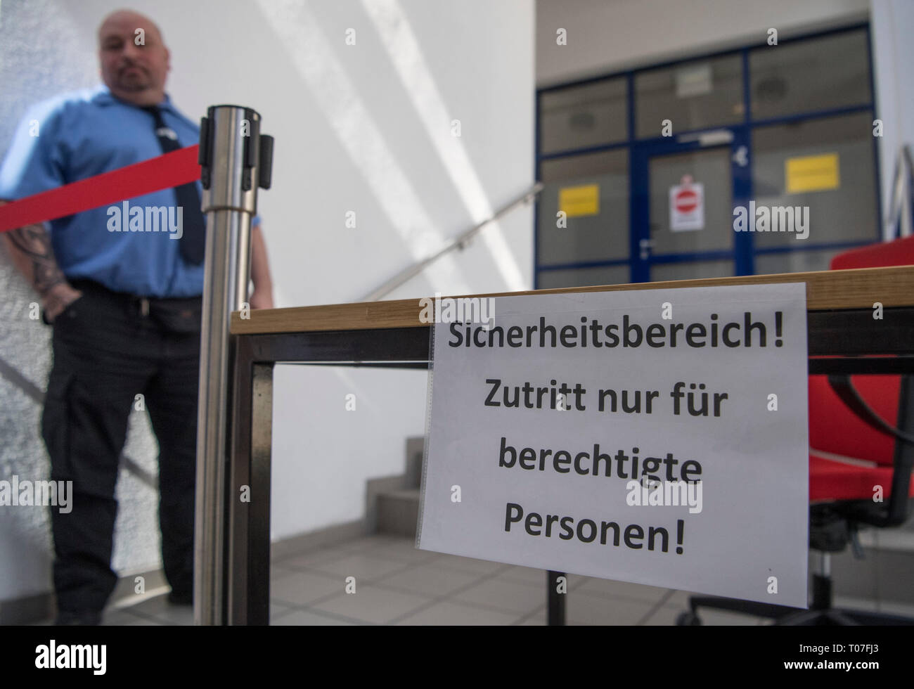 Mainz, Deutschland. 18 Mär, 2019. Ein Wachmann steht vor einer bereits abgeschlossenen Gebäude Abschnitt der Bundesnetzagentur, in denen 41 Frequenzblöcke wird zu verschiedenen Anbietern ab Dienstag (19. März) versteigert werden. Die Auktion dauert mehrere Wochen. 5G ist von großer Bedeutung für die deutsche Industrie. Credit: Boris Roessler/dpa/Alamy leben Nachrichten Stockfoto