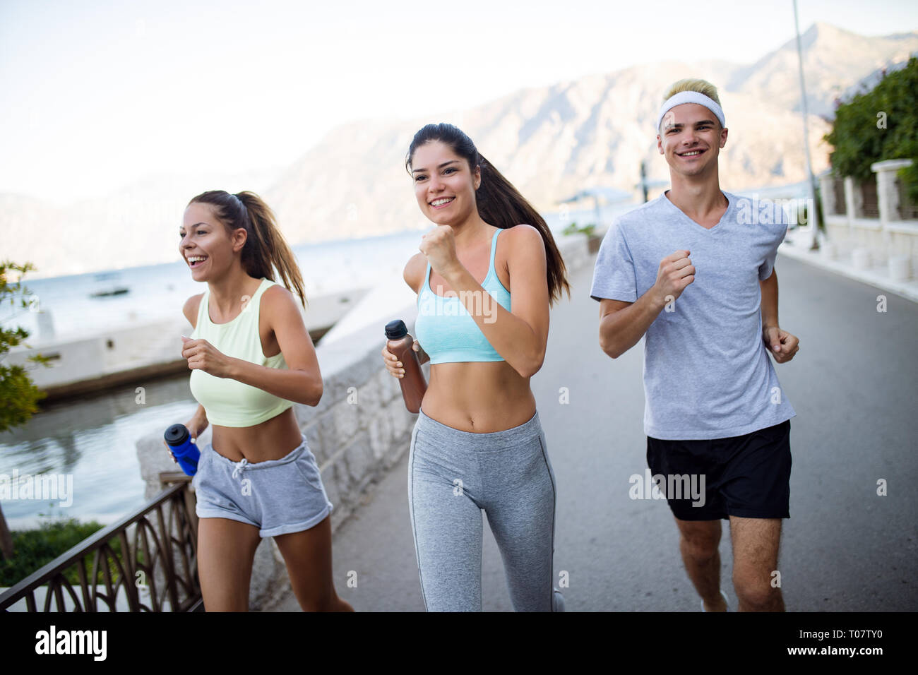 Glückliche Menschen Joggen im Freien. Laufen, Sport, Bewegung und gesunde Lebensweise Konzept Stockfoto