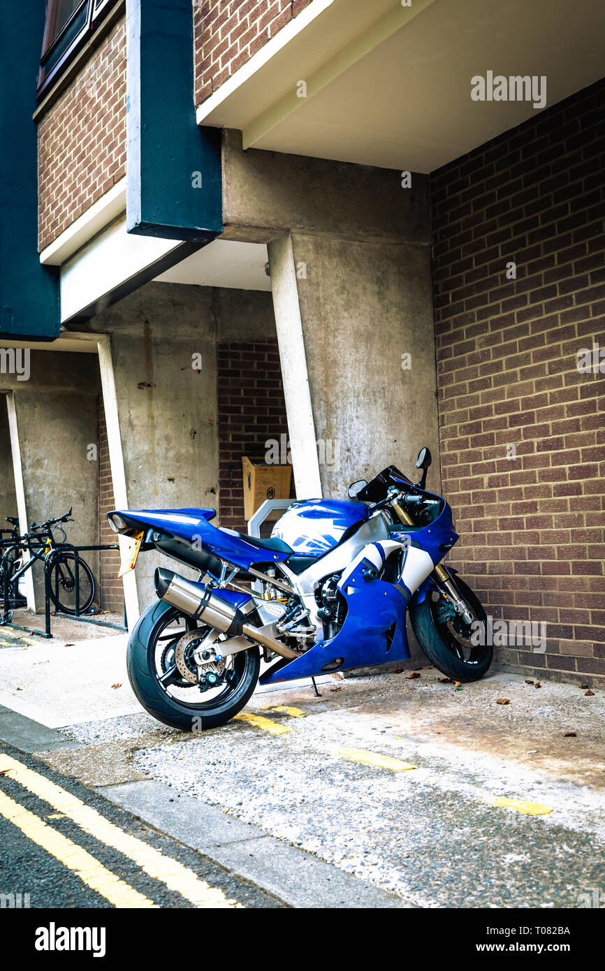 Blau und Weiß sport Motorrad auf einem Weg geparkt neben einem modernen Gebäude in Newcastle upon Tyne, Tyne und Wear, Großbritannien Stockfoto