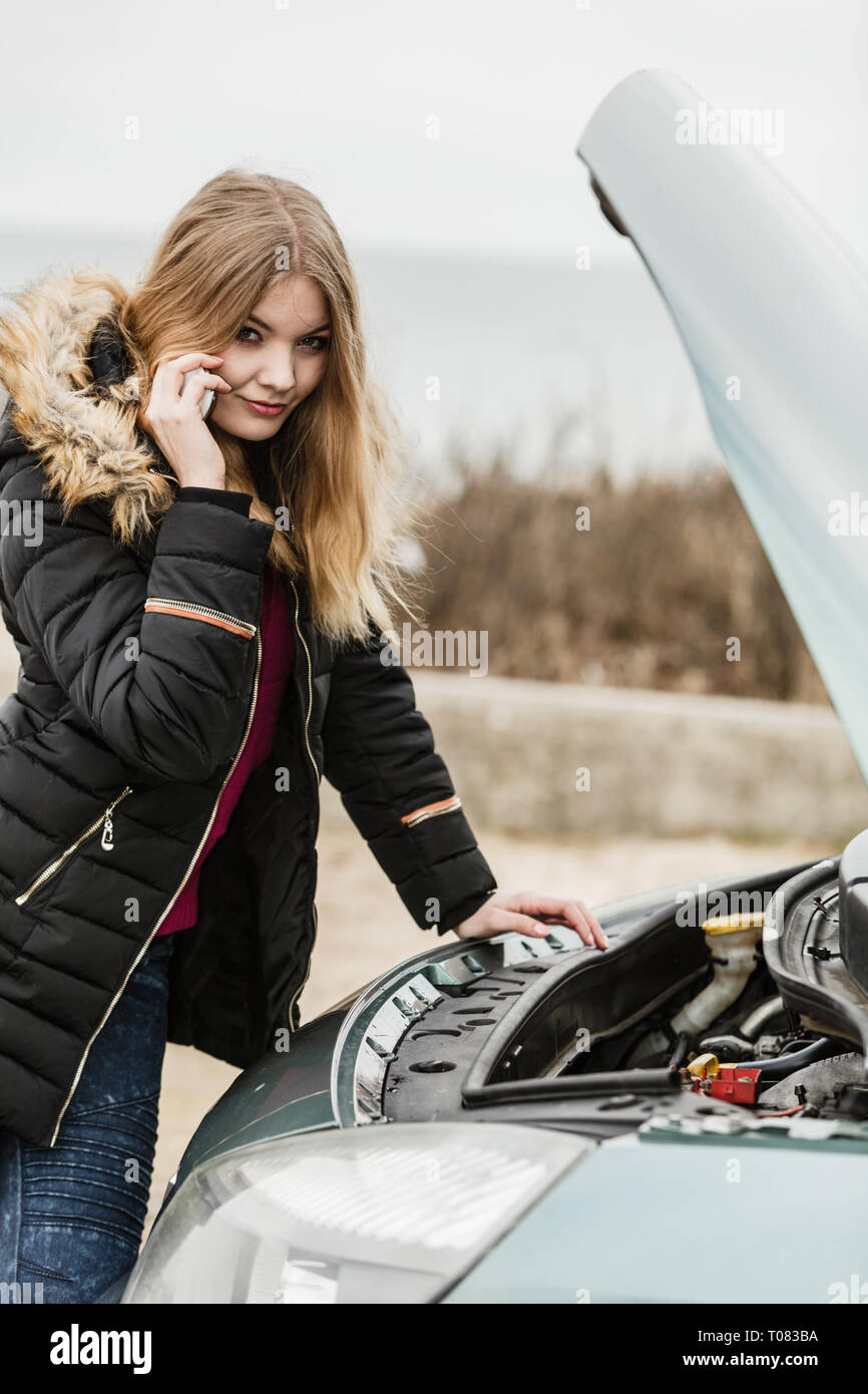 Unfälle und Pannen mit auto Konzept. Unten gebrochen Auto, blonde Frau in Problem, rufen sich jemand um Hilfe. Stockfoto