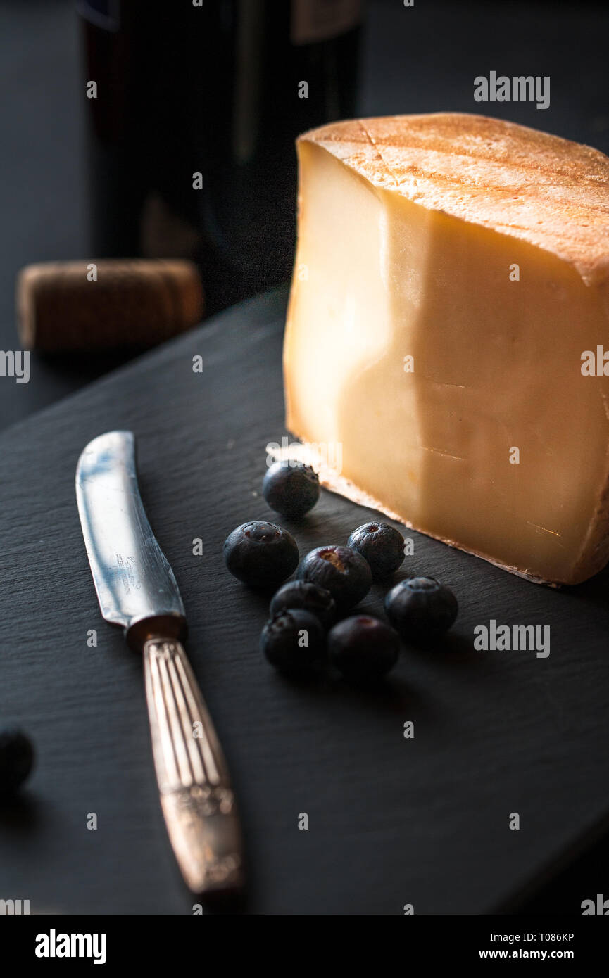 Käse Wein und Beeren mit antiken Messer, Korkenzieher, Gläser und eine Flasche Wein. Stockfoto