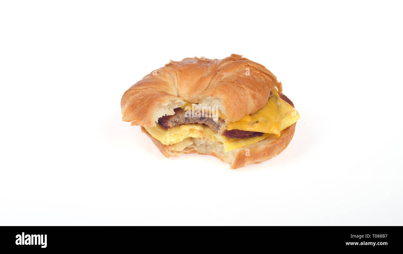 Burger King Würstchen, Eier und Käse Frühstück croissanwich oder Croissant Sandwich mit Bissen genommen Stockfoto