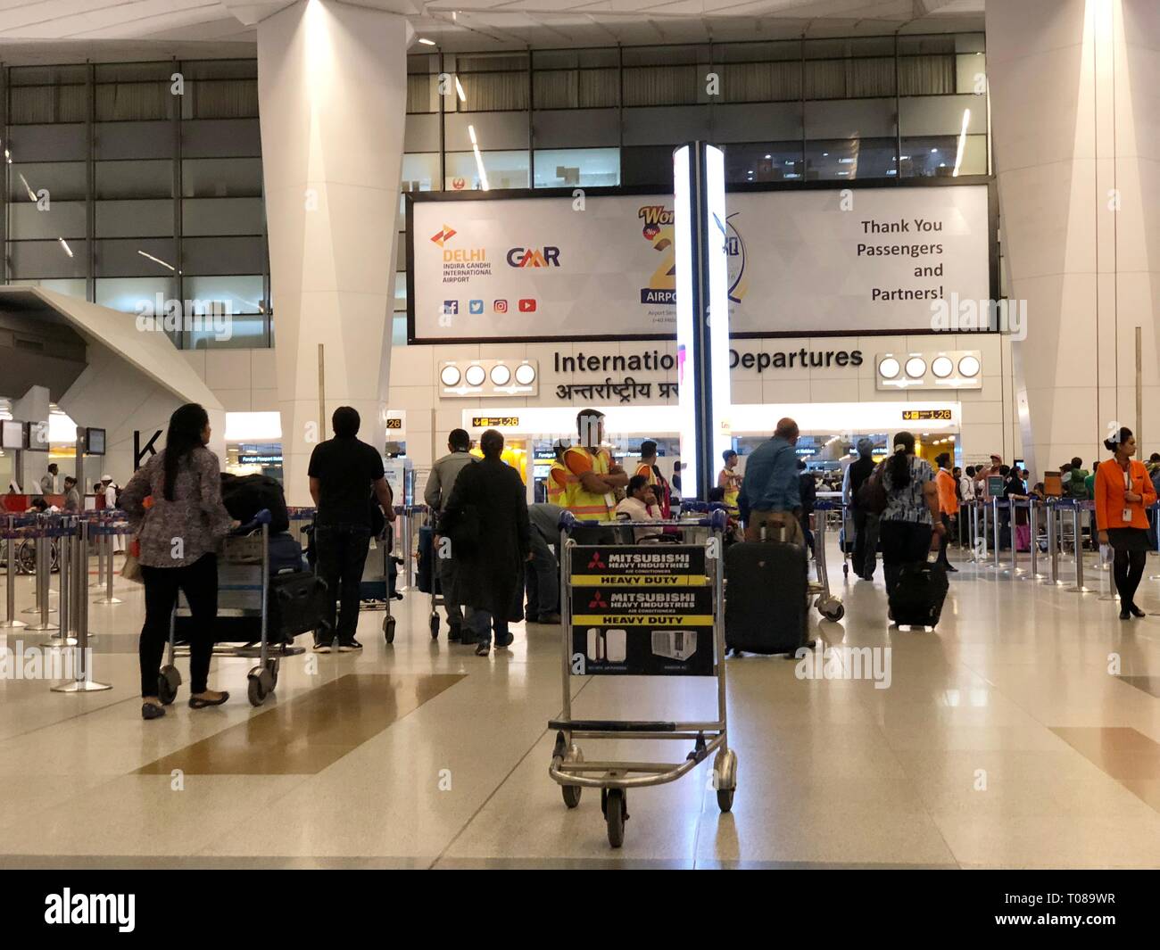 NEU-DELHI, INDIEN – 2018. MÄRZ: Passagiere schieben Gepäckwagen auf den internationalen Abflugsteig des Indira Ghandi International Airport in New Stockfoto