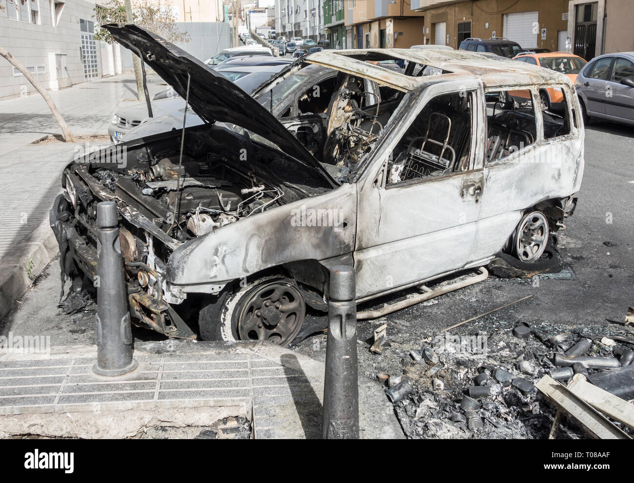 Ausgebrannte Autos, die neben Müll container angezündet durch Vandalen in der Straße geparkt waren in Spanien Stockfoto