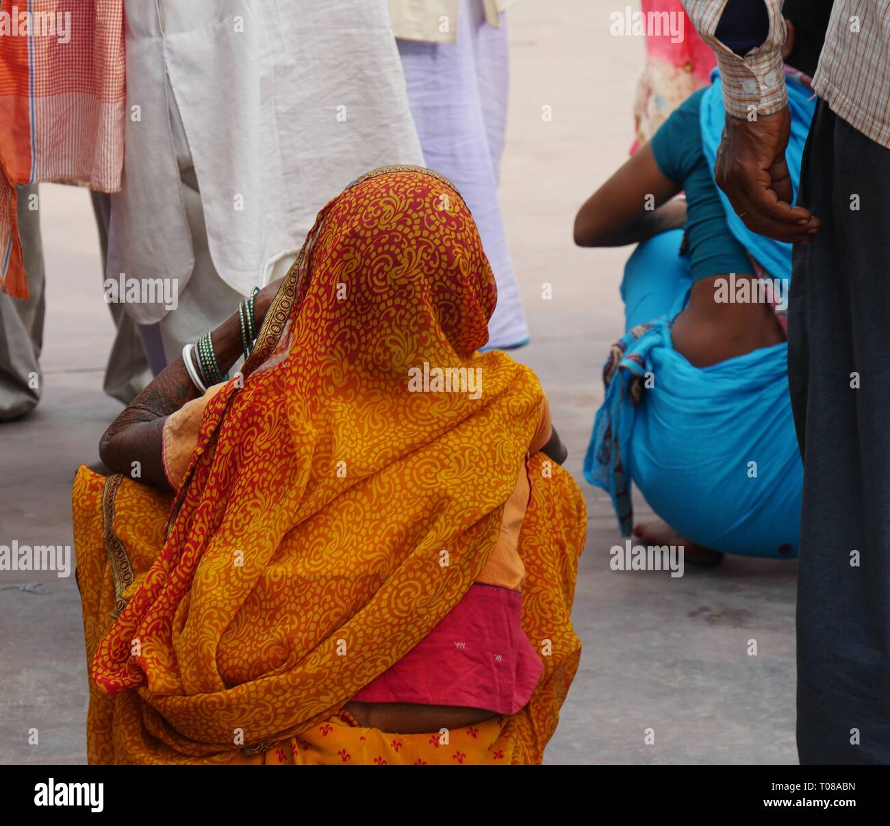 AGRA, UTTAR PRADESH, INDIEN - 2018. MÄRZ: Frauen in farbenfroher traditioneller indischer Kleidung hocken, um Eintrittskarten zu erhalten Stockfoto