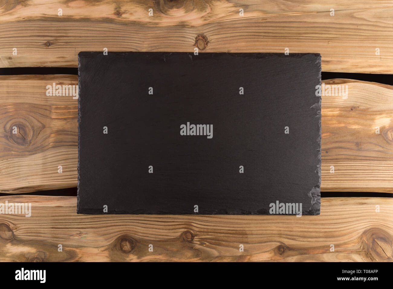 Schiefer server/Board/Fach auf rustikale Holzplanken. Schiefer texturierte flachen Stein Festlegung Hintergrund mit Platz für Text-, Lebensmittel-, Banner- oder die MENU-Konzept. Ansicht von oben Stockfoto