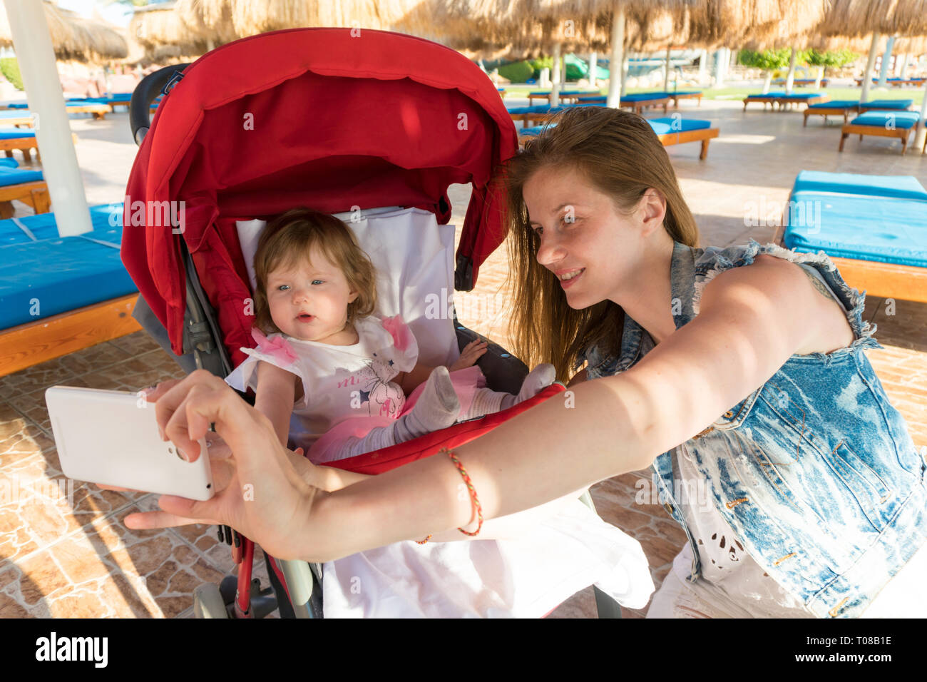 Mutter unter selfie mit Baby auf Resort Stockfoto Mutter unter selfie mit Baby auf Resort Stockfoto