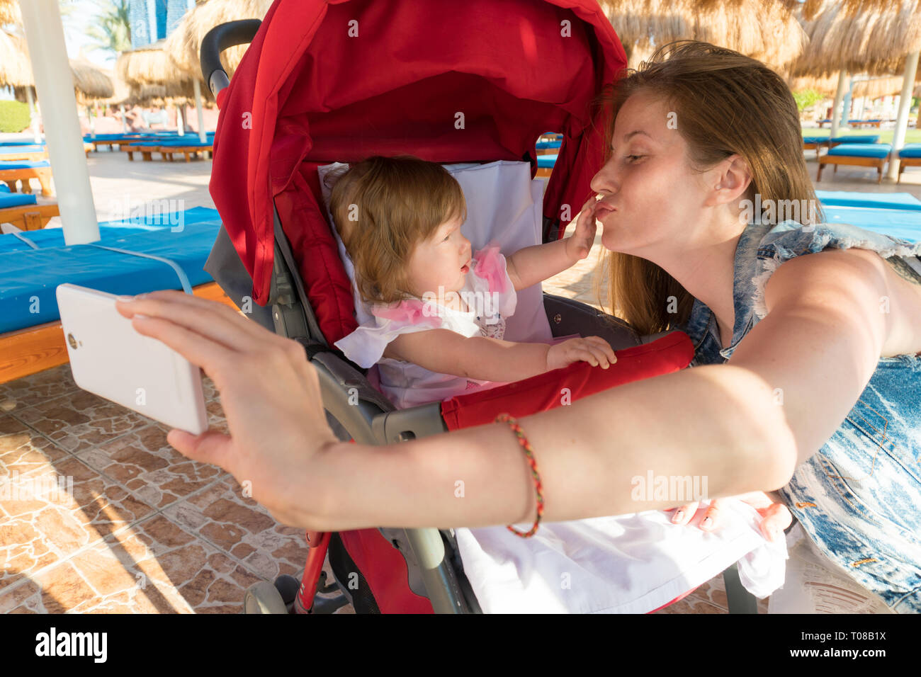 Junge Frau von selfie mit Baby auf Resort Stockfoto