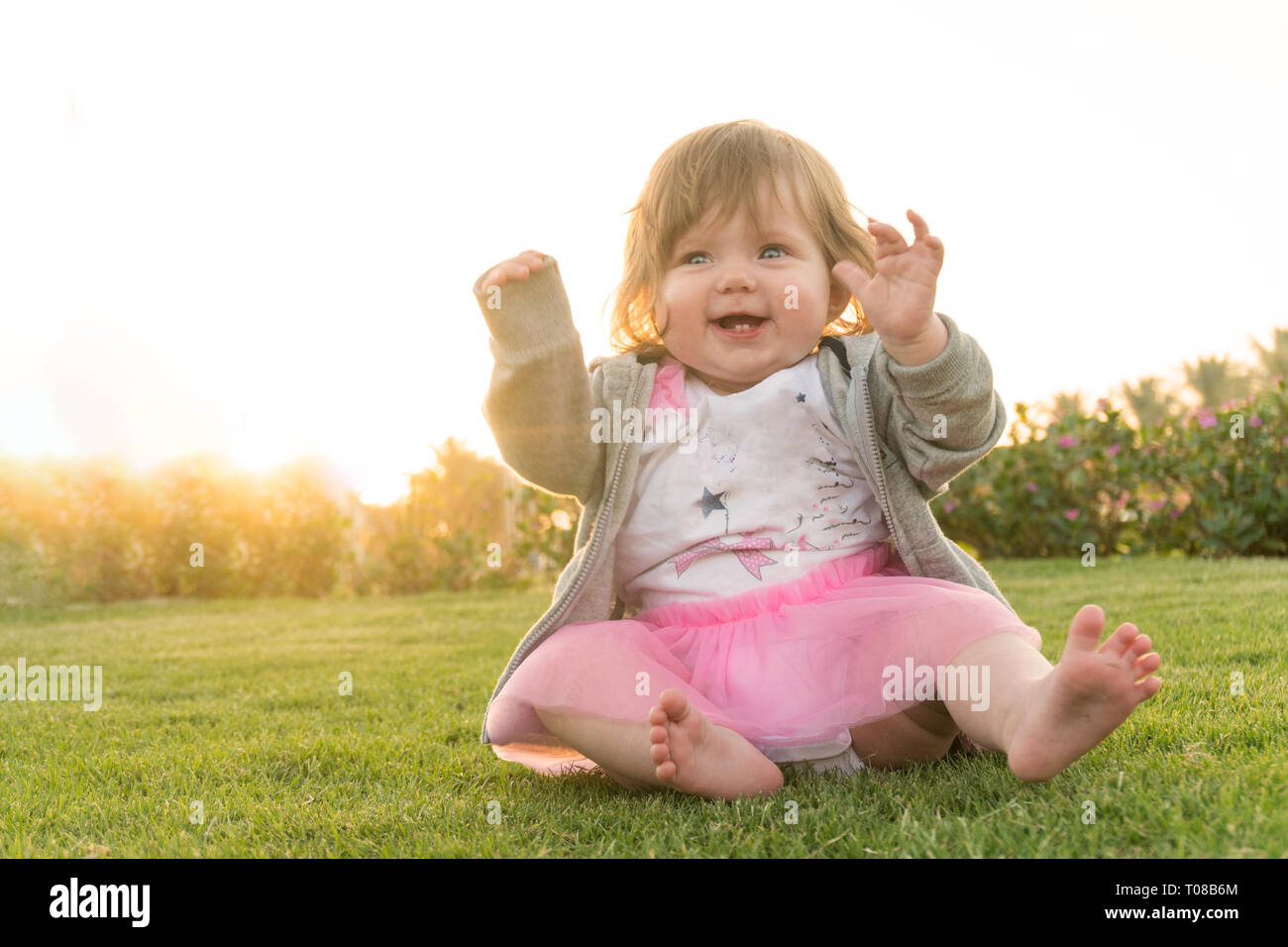 Lächelnd kleine süße Mädchen Spaß im Gras Stockfoto