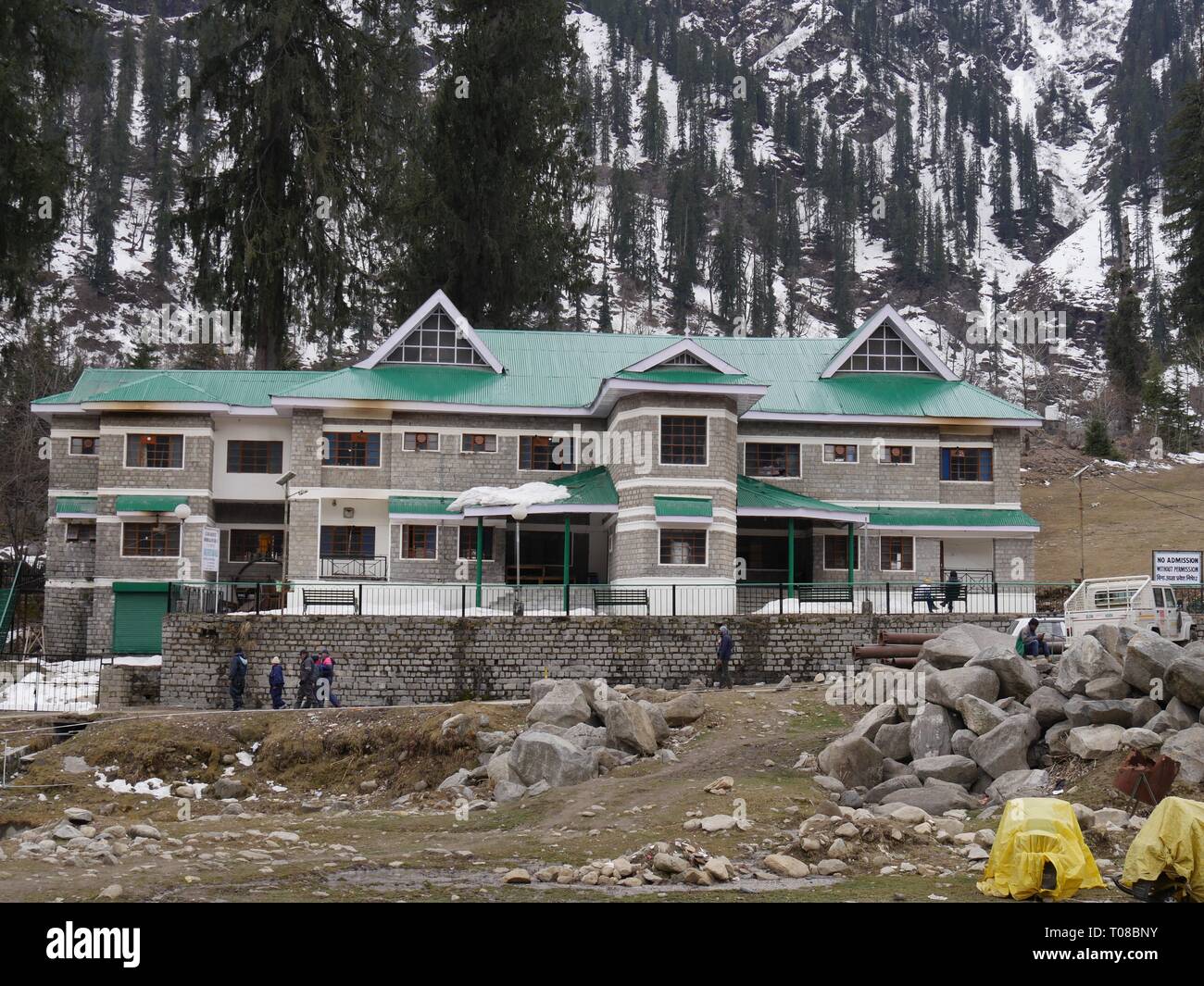 SOLANG VALLEY, HIMACHAL PRADESH – 2018. MÄRZ: Resortgebäude am Fuße der schneebedeckten Berge im Solang Valley, Himalaya. Stockfoto