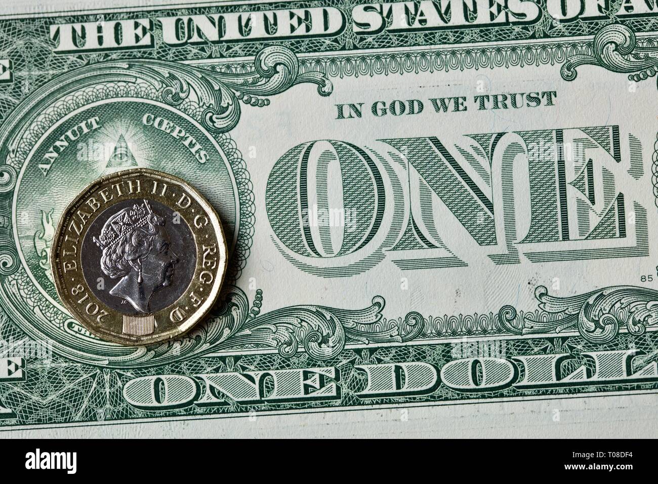 Sterling Pound Münze auf einen US-Amerikanischen Dollar Bill Stockfoto