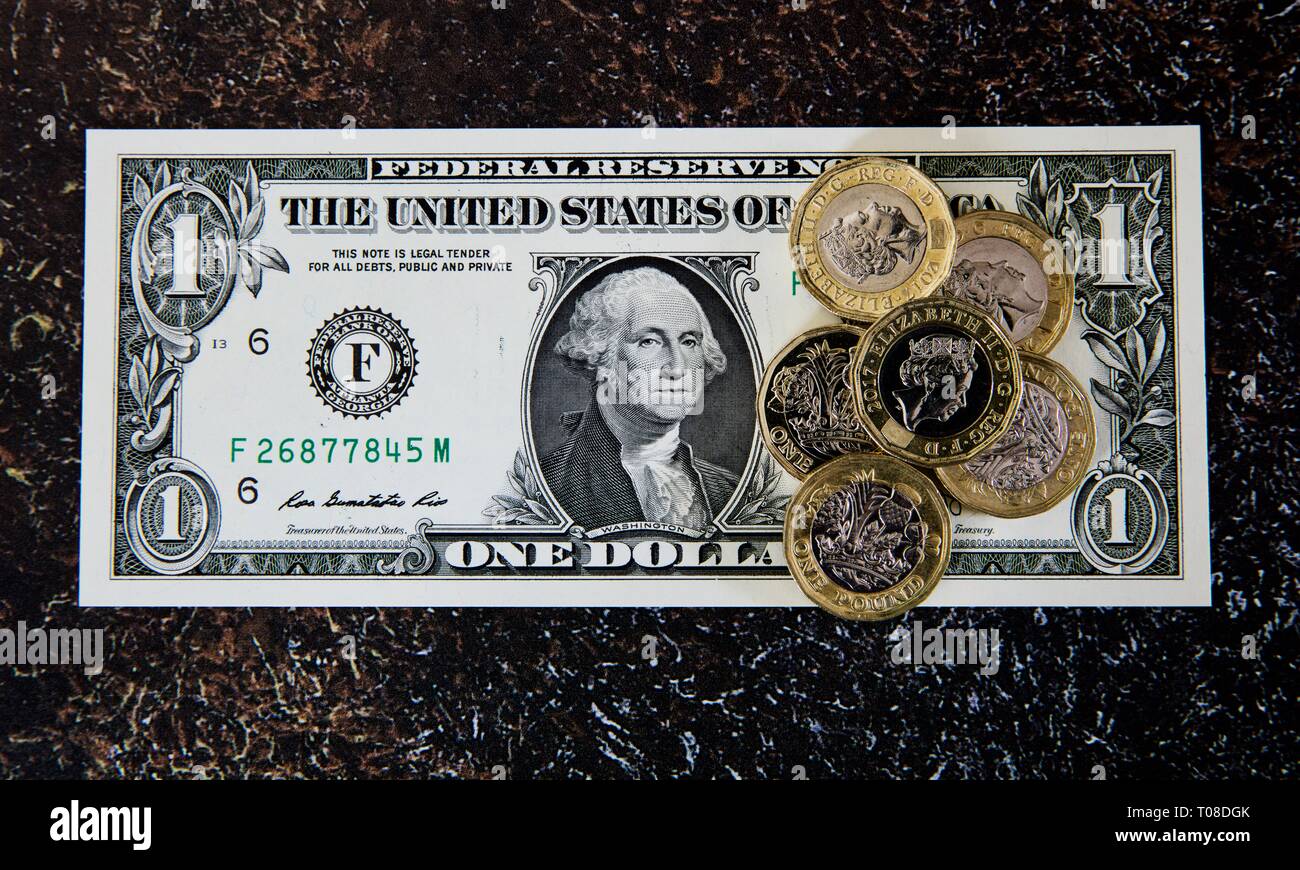 Sterling Pound Münzen auf einen US-Amerikanischen Dollar Bill Stockfoto