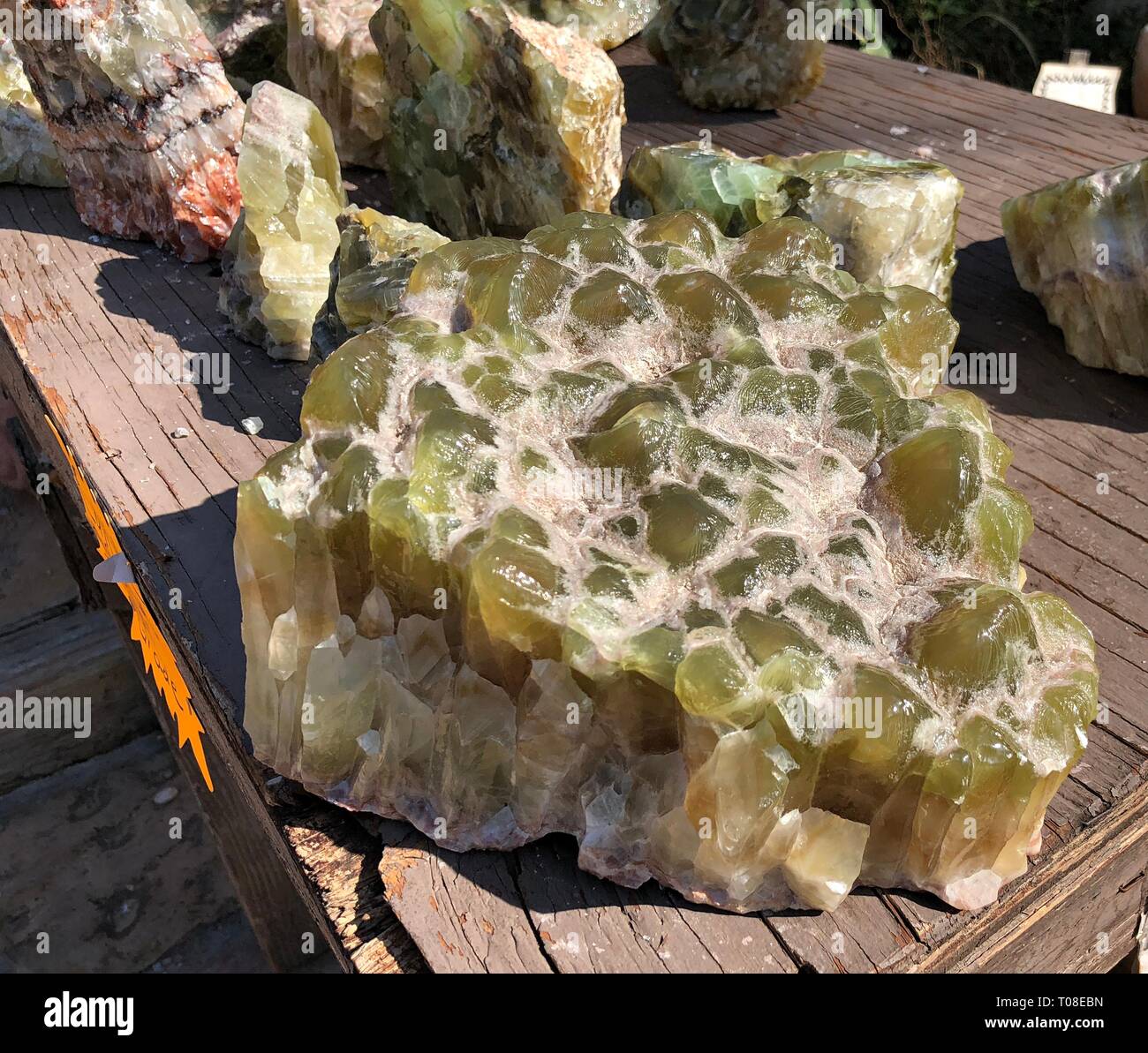 Nahaufnahme einer großen Platte aus grünem Kalzitgestein Auf einem Holztisch Stockfoto