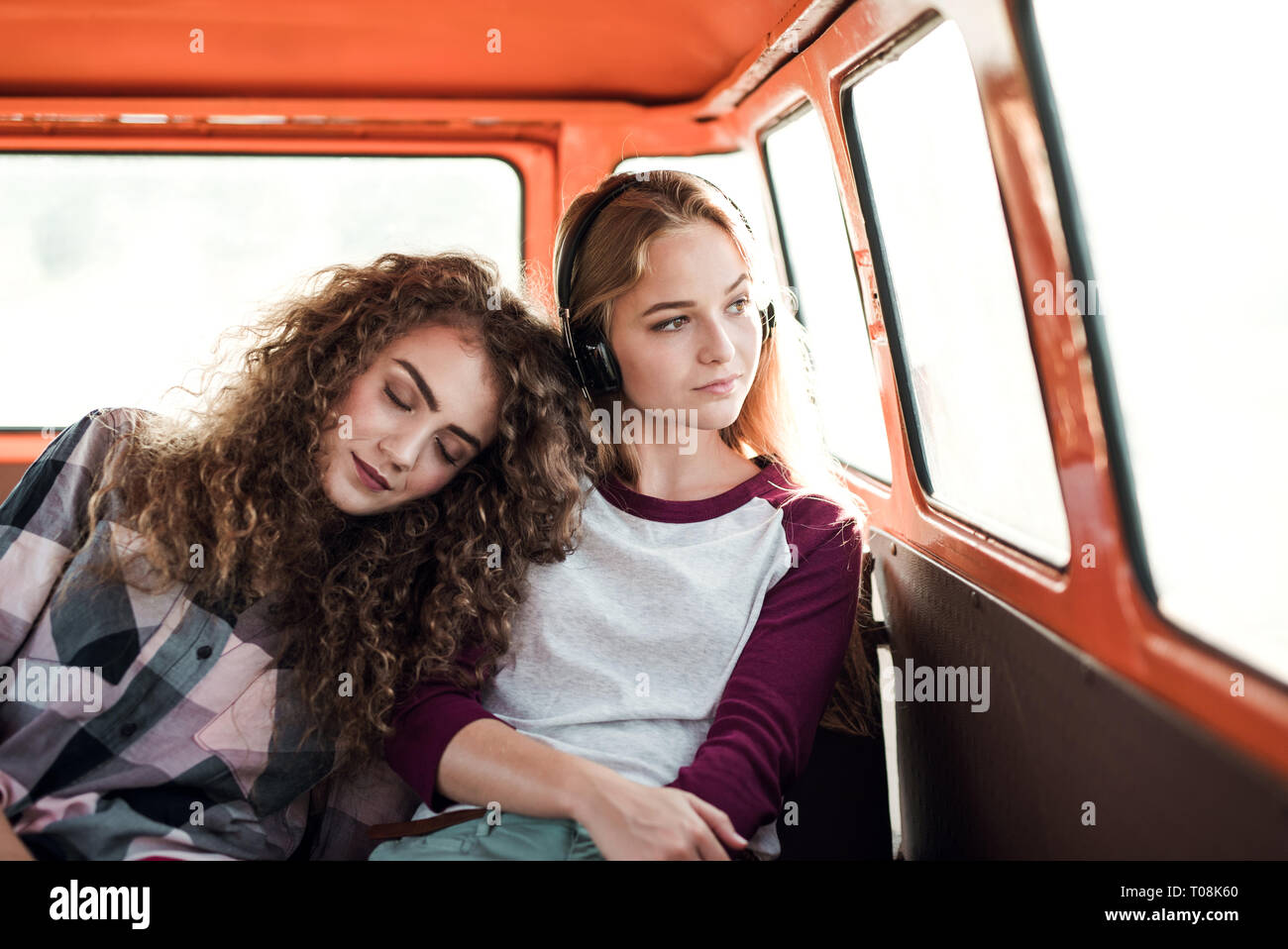 Junge weibliche Freunde auf einem Roadtrip durch Landschaft, in minivan sitzen. Stockfoto