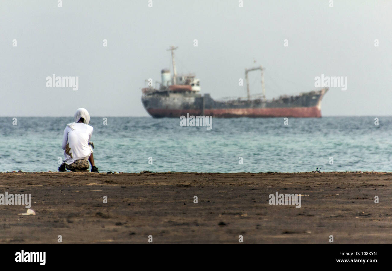 eritreische Männer beobachten ein Boot von der Küste aus, massawa, eritrea Stockfoto