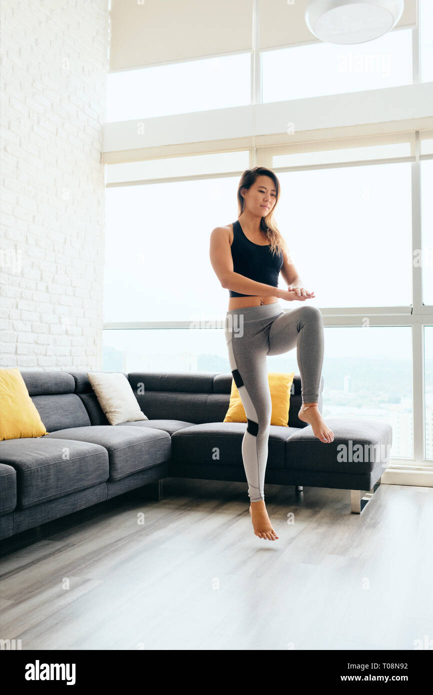 Erwachsene Frau Training ABS und Beine tun Hohe Knie Tippen Stockfoto