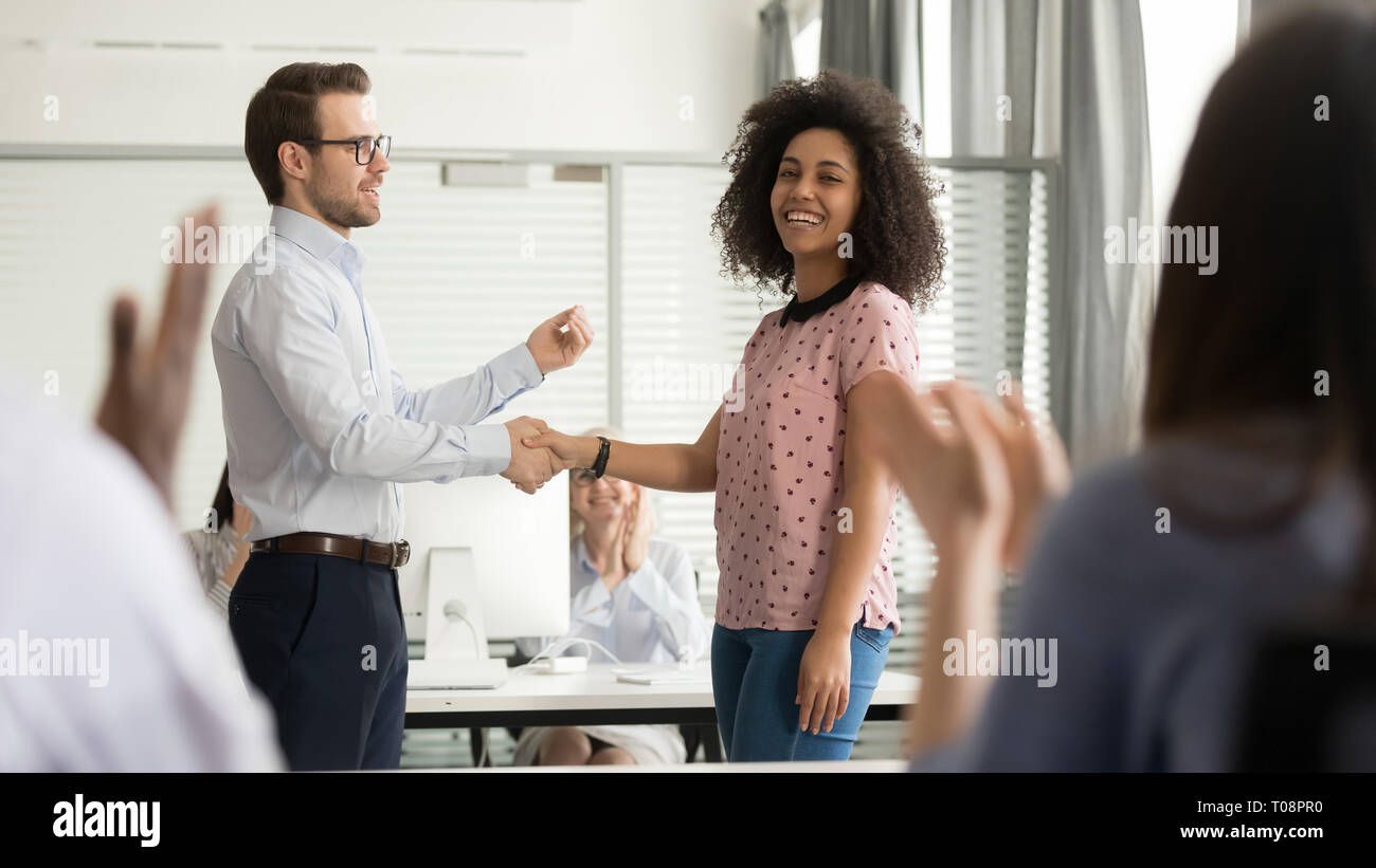 Hilfsbereit Chef handshaking glücklich afrikanischen Mitarbeiter Förderung lohnende Arbeitnehmer beglückwünschen. Stockfoto